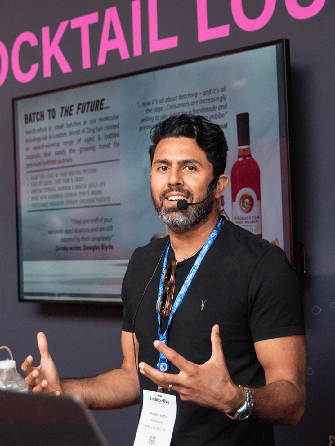 A beverage specialist speaking to a crowd of people