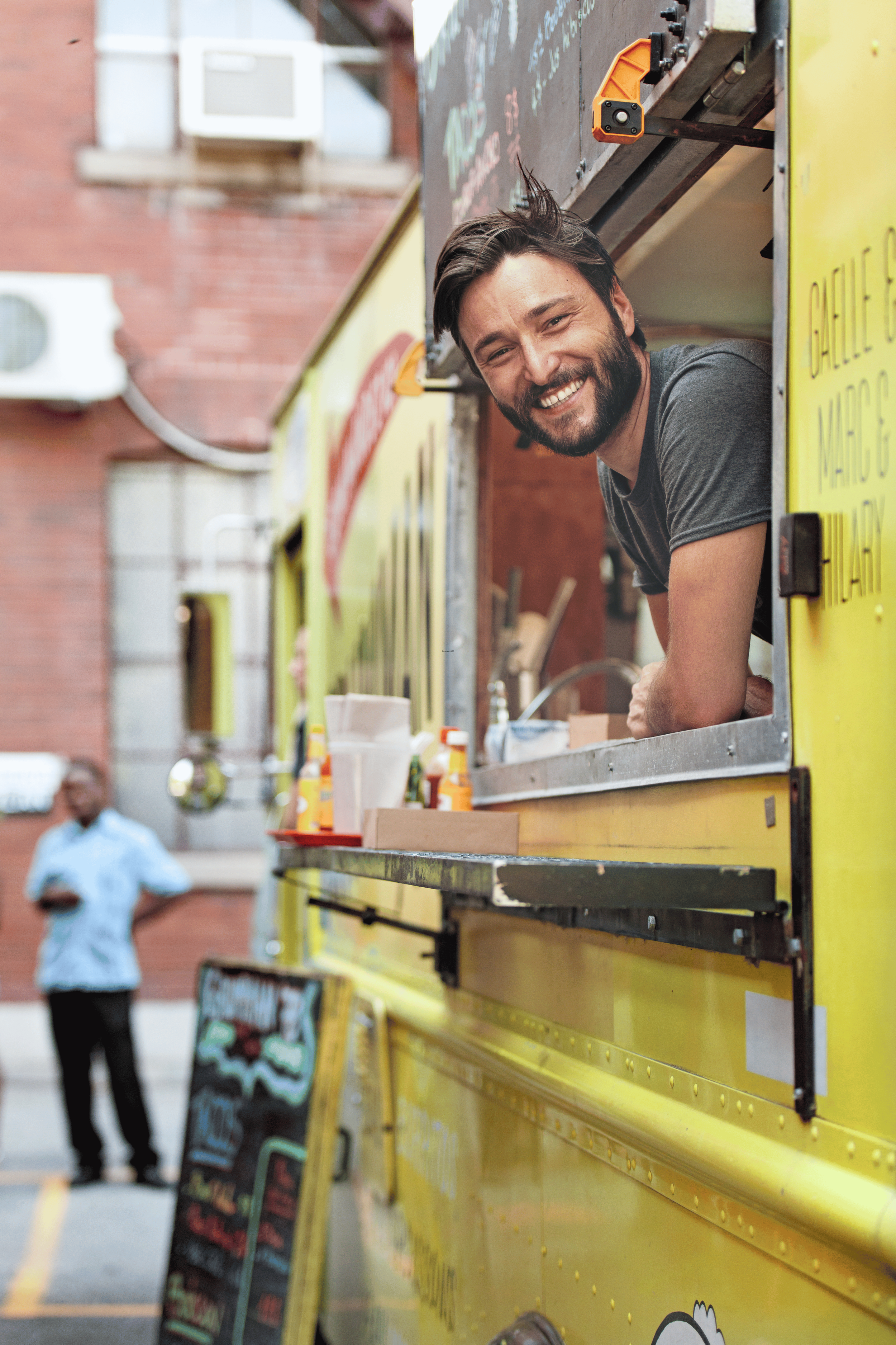Food vendor smiling out of food truck