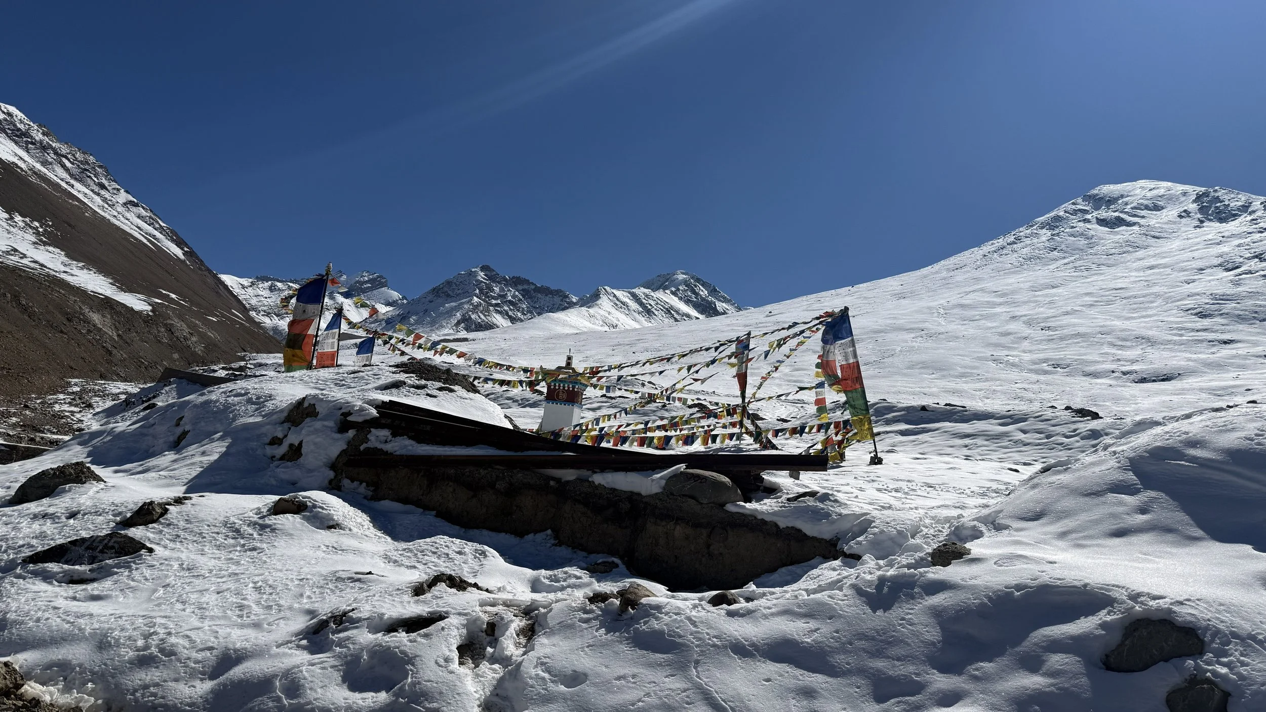 Prayer flags and snow-covered mountains on the way to Kunzum La Pass in Spiti Valley.