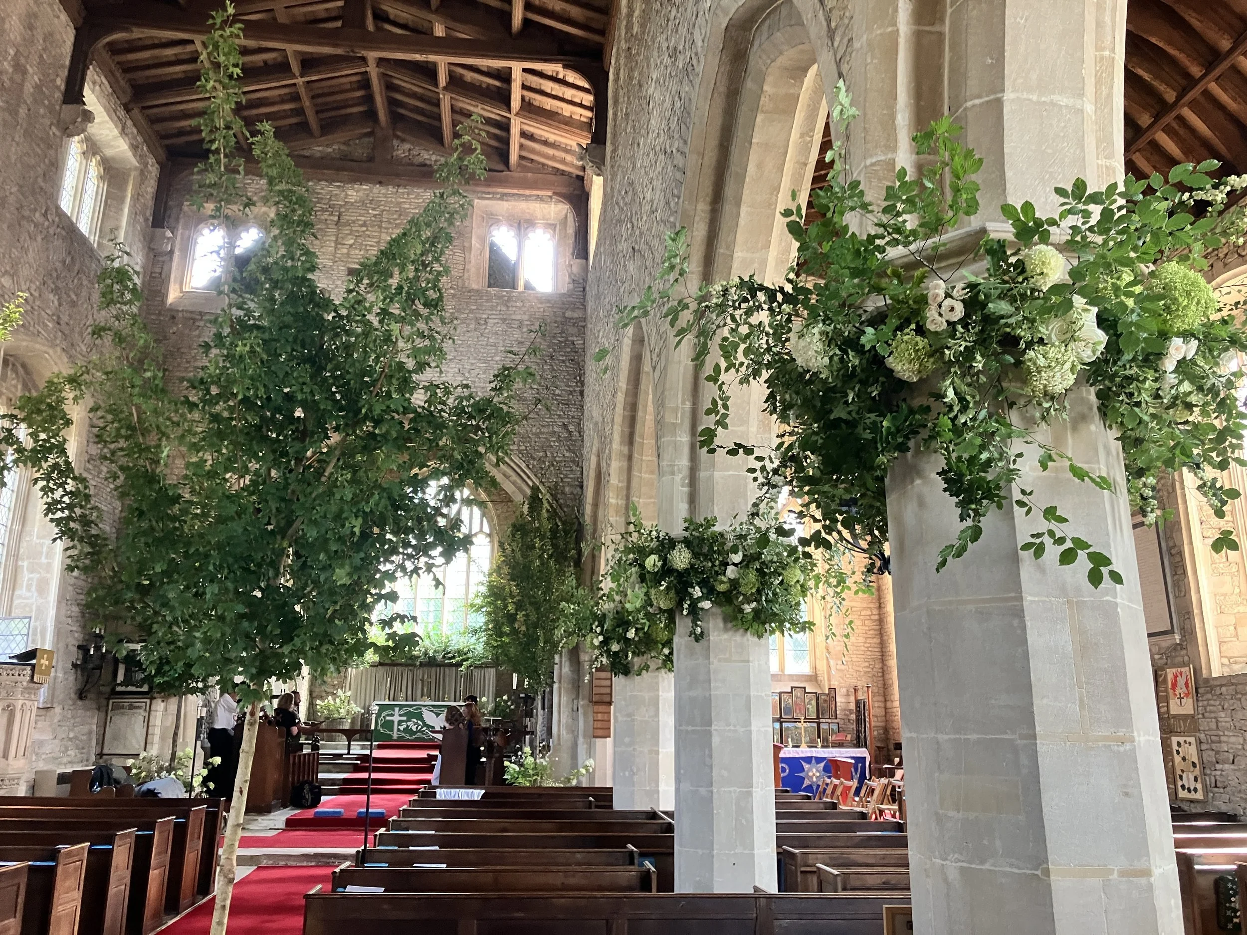 Stunning interior floral displays at St Mary the Virgin Church in Hawkesbury Upton, Gloucestershire with the organist Ben Humphries playing at this wedding ceremony. 