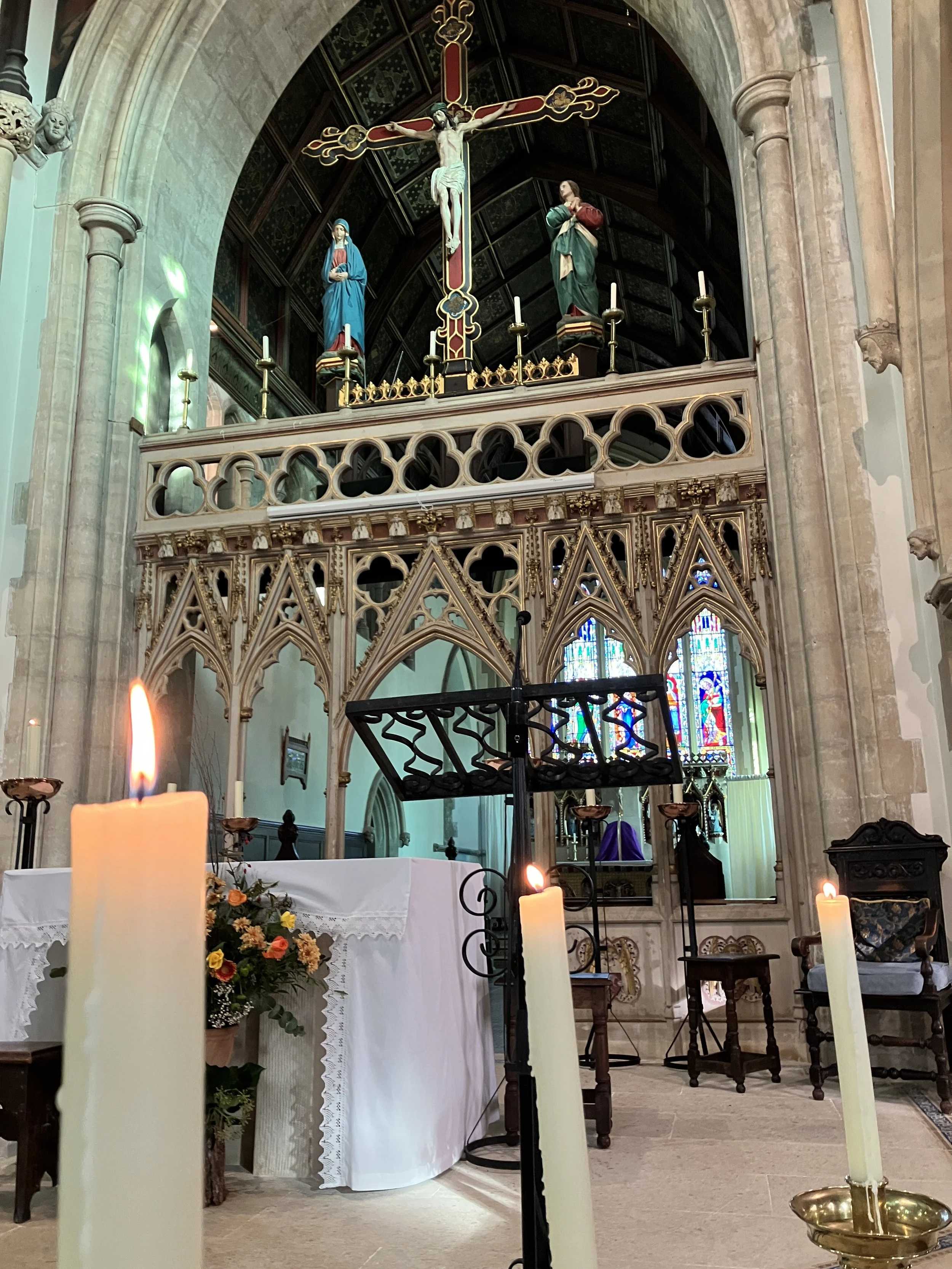 The chancel crossing and candlelight during the funeral service near Stroud, the Priory Church of the Annunciation in South Woodchester where organist Ben Humphries is playing the organ.