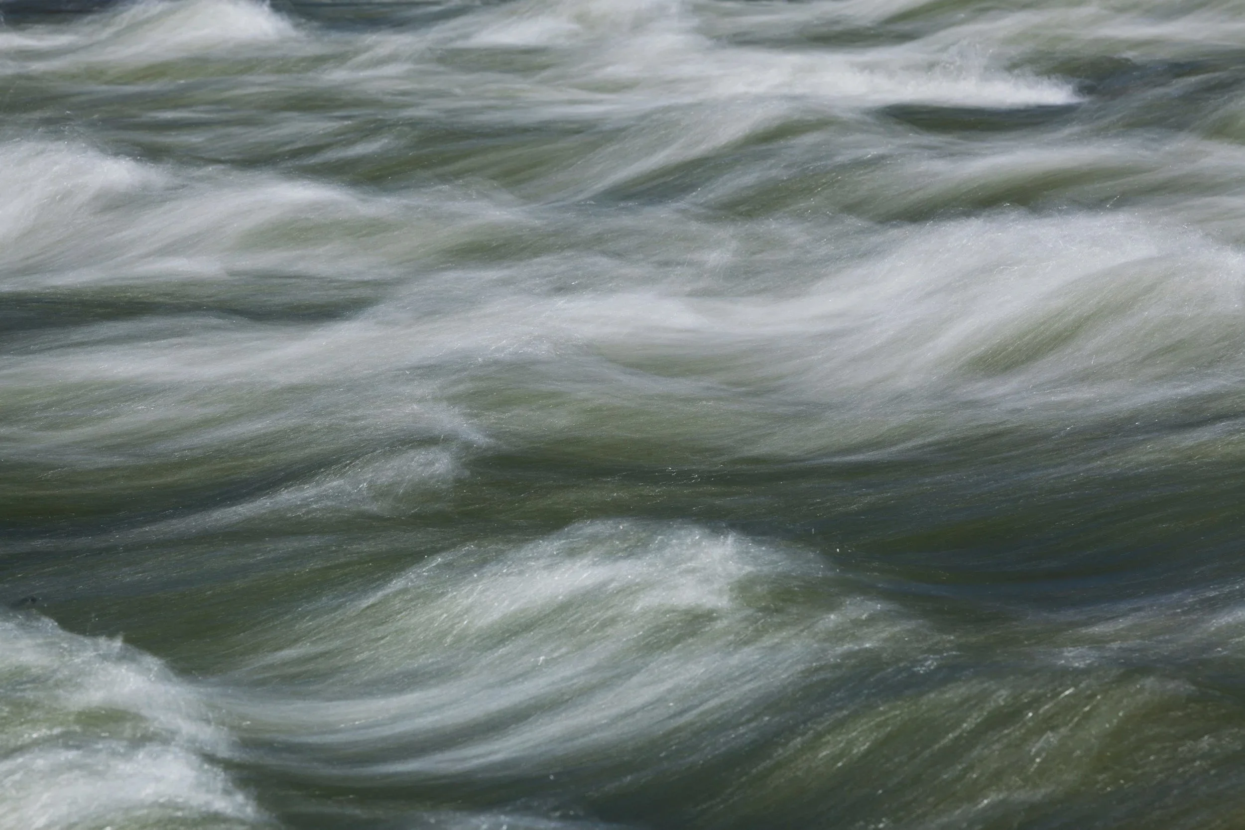 Choppy water surface with waves and foam.
