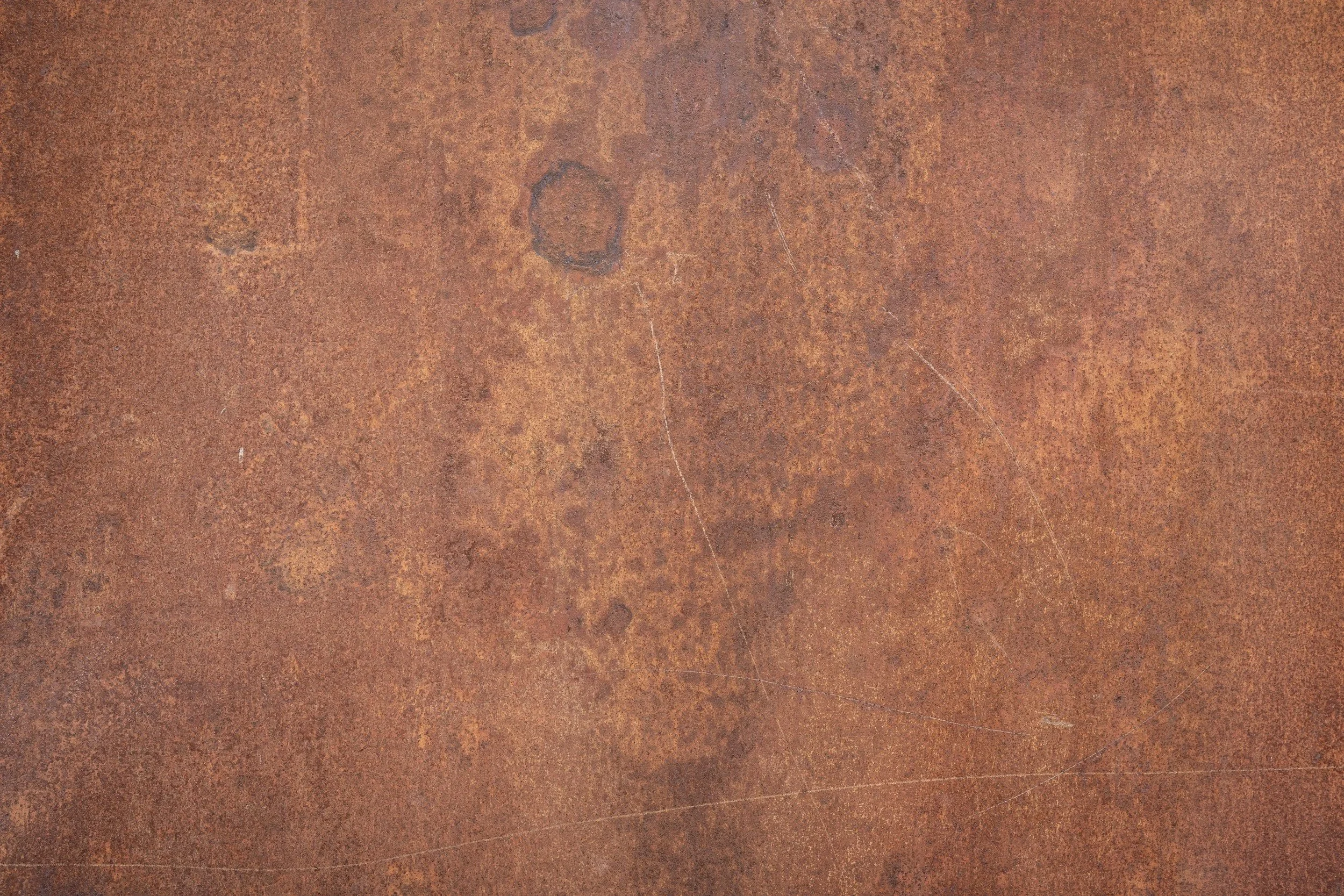 Close-up of a rusty, textured metal surface with various shades of brown and orange.