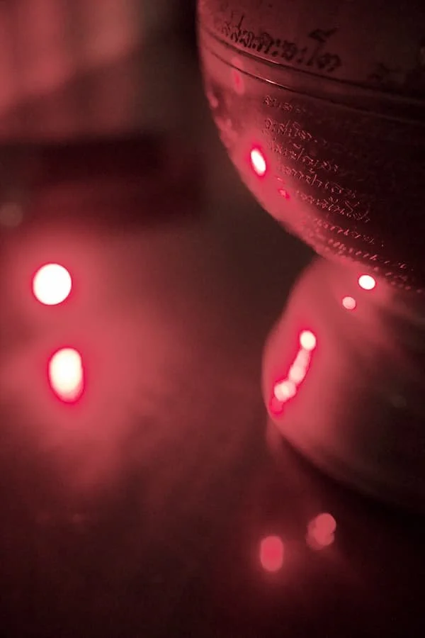 Red Light Therapy device shining the healing light on the mirror and the antique gold bowl