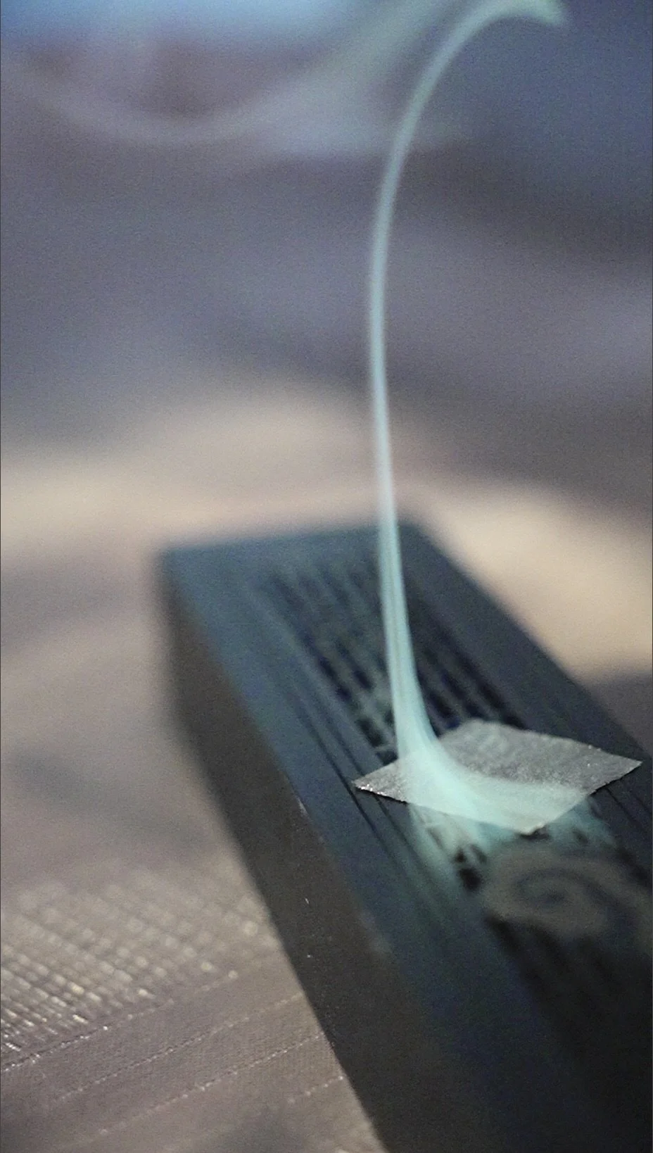 Close-up of a incense burner with gold leaf letting the smoke out beautifully and calmly.