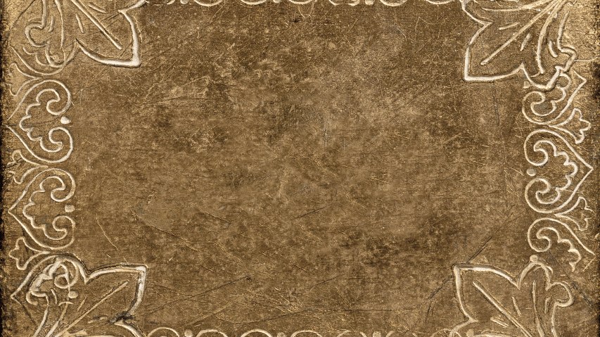 A close-up of a textured, brown leather surface with ornate, decorative floral patterns in the corners.