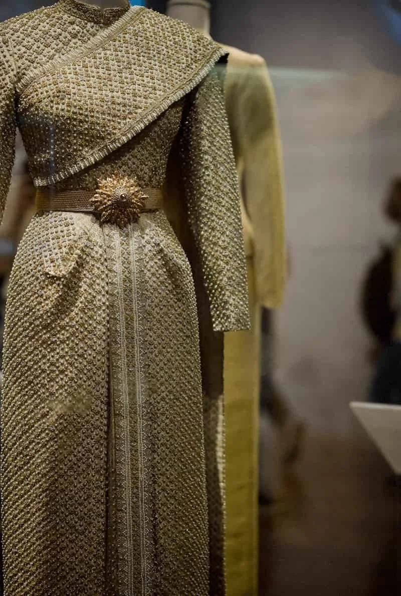 A sophisticated queen Sirikit costume made of golden Thai silk representing the eastern heritage and Thai craft