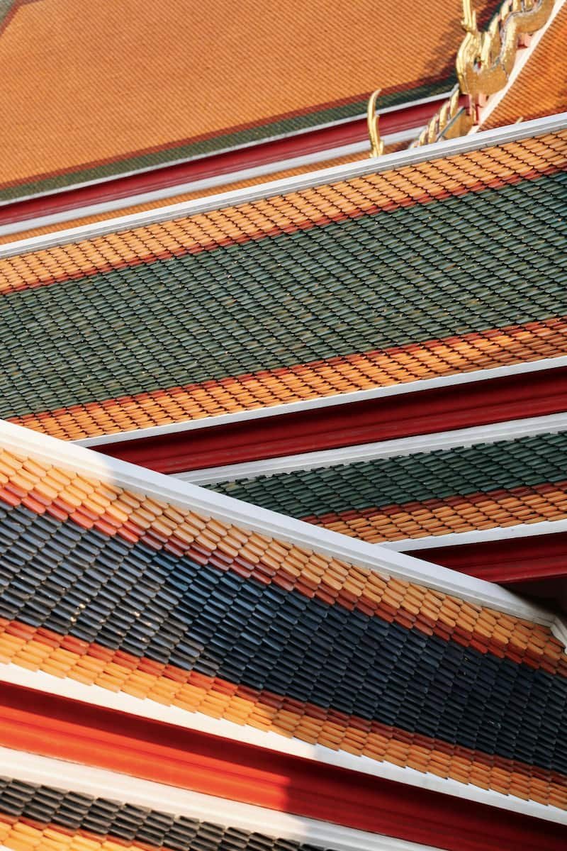 Thai temple roof in orange, blue and green.