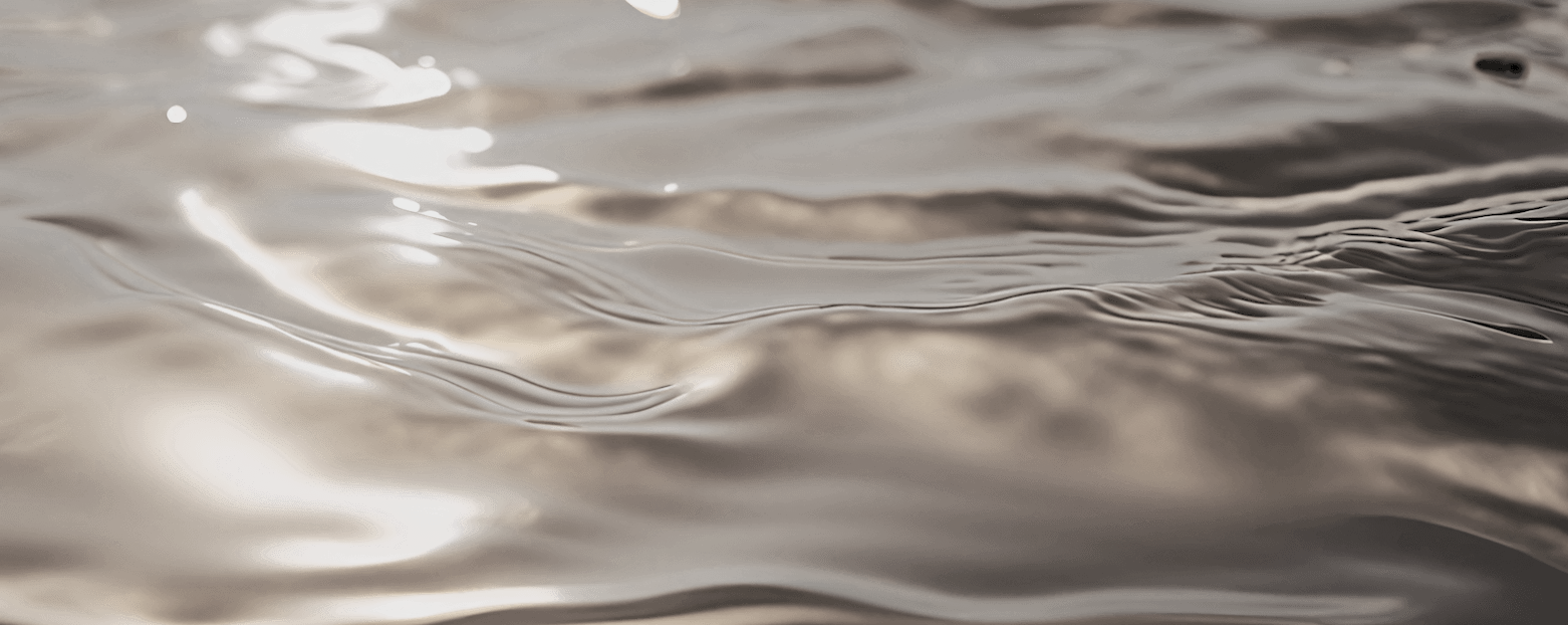 Close-up of water with warm, golden reflections and gentle ripples.