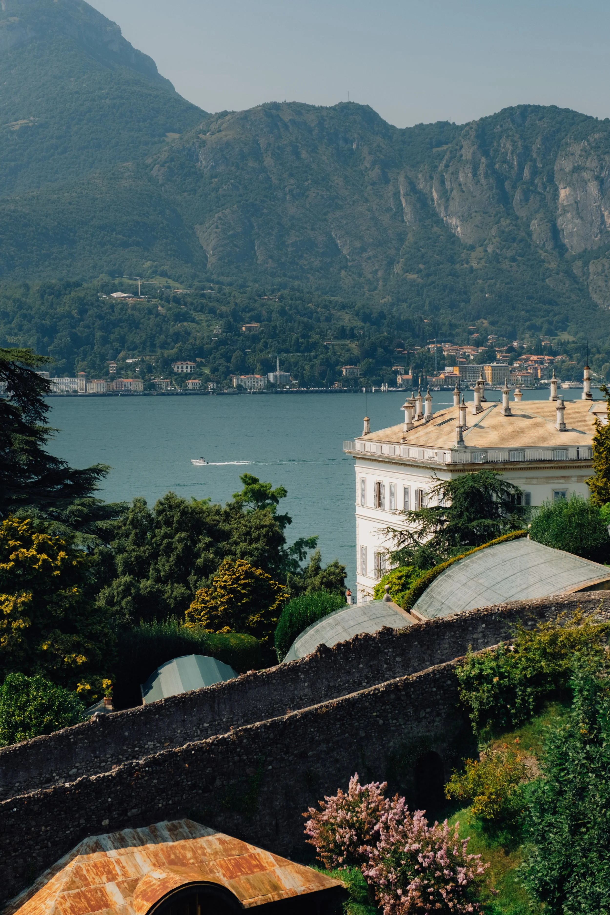 View looking out over Lake Como from the manicured gardens of a historic villa.