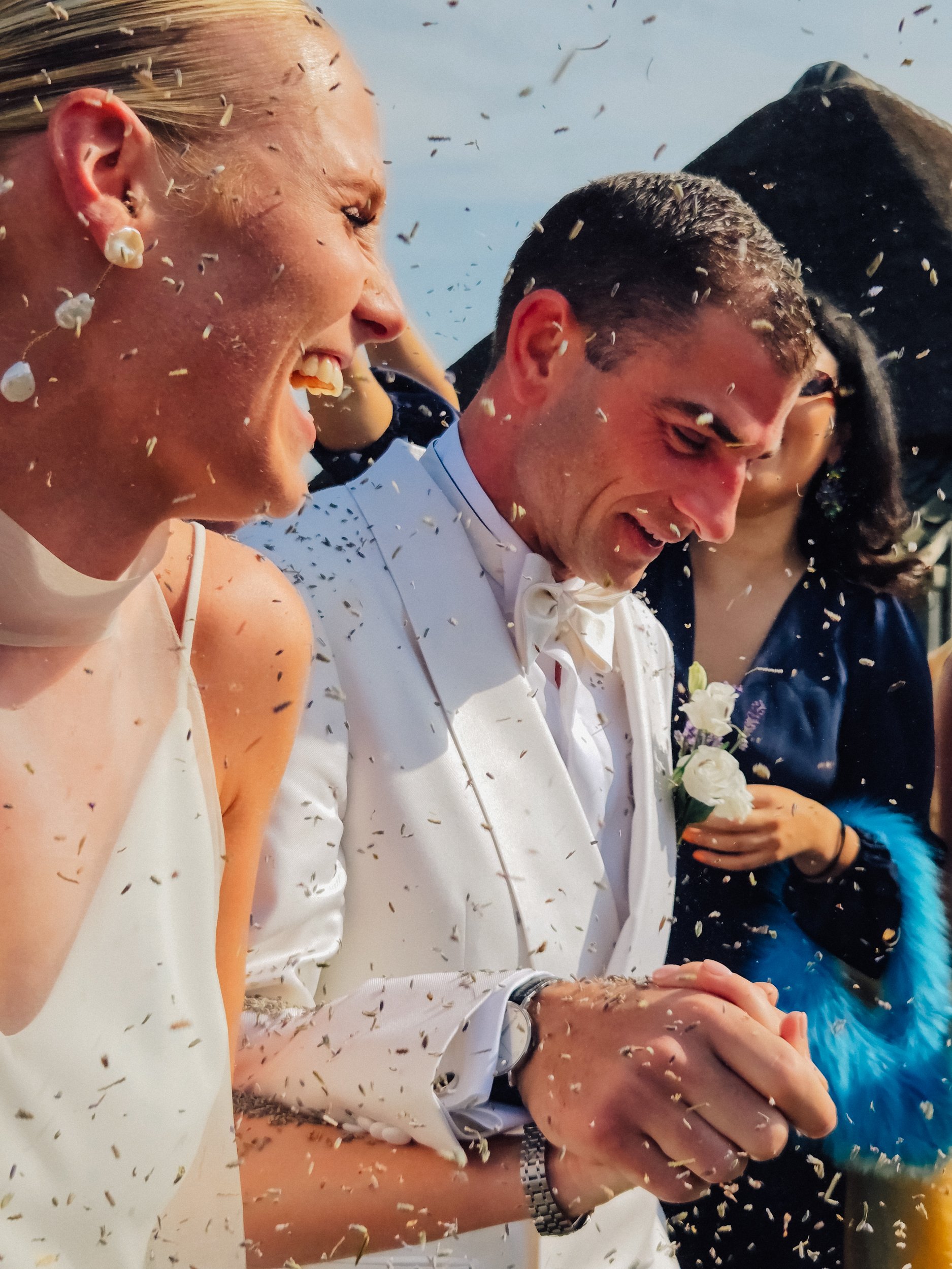 High-end wedding photograph of a couple walking down the isle while rice is raining down on them, very dynamic and cinematic shot.