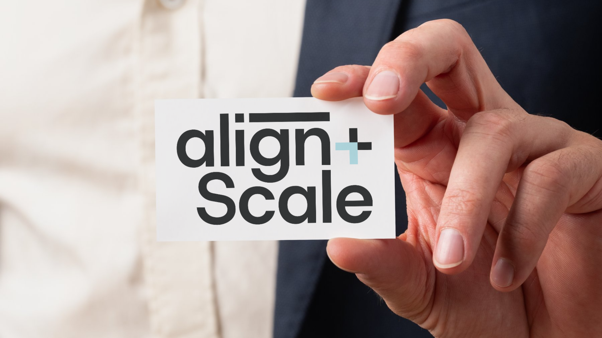 Hand holding a business card with the words "align + scale" on it.