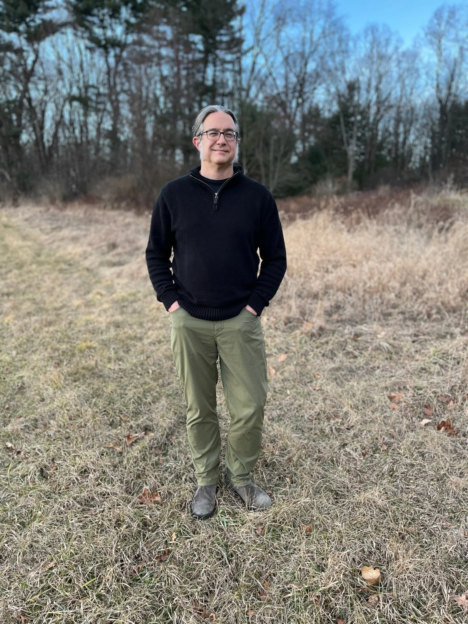 David Archibald standing on a grass path with woods in the background
