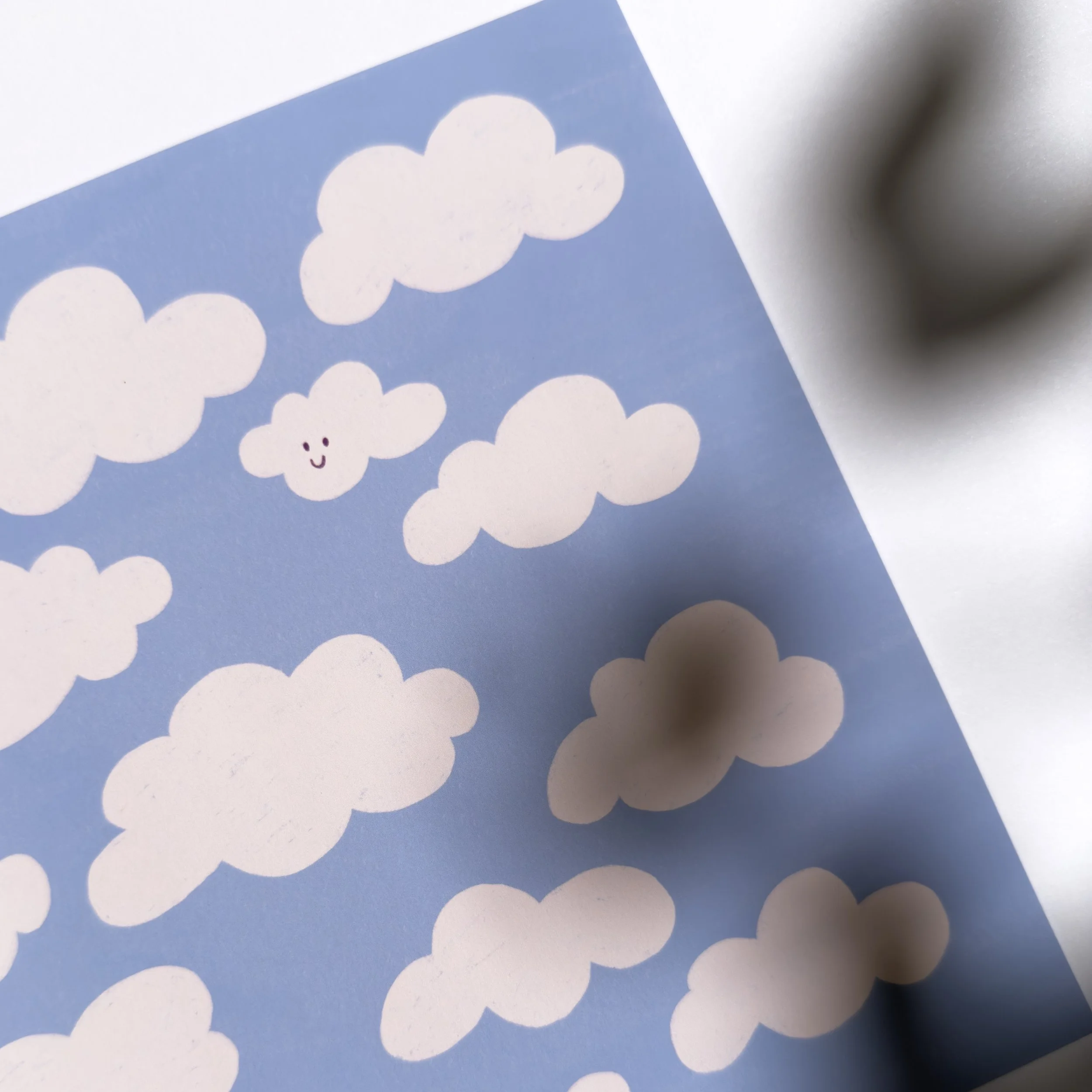 Une série de nuages blancs avec un visage souriant sur un fond bleu.