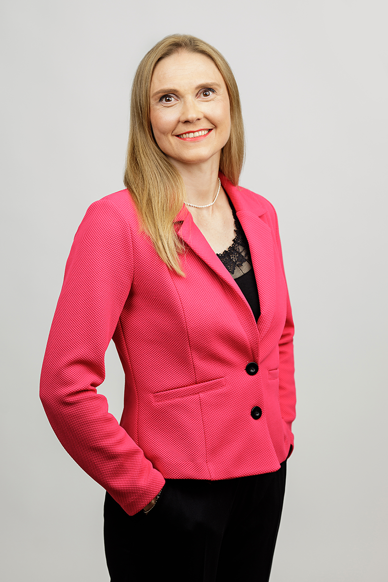 Business Coach ja Urheilupsykologi Mari Kalliolahti-Oja hymyilee kameralle.