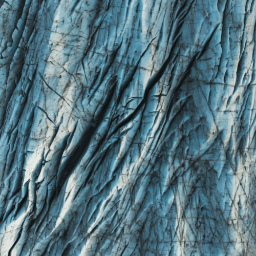 Close-up of a textured blue fabric with visible creases and wrinkles.