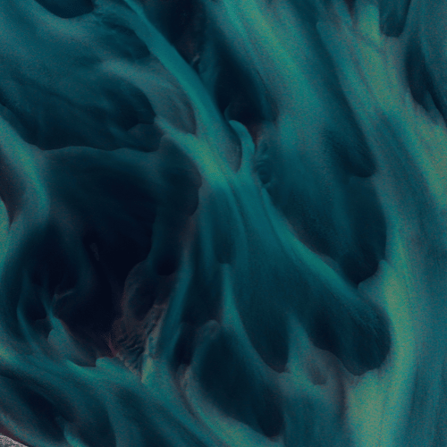 Abstract swirling blue and green ink in water.