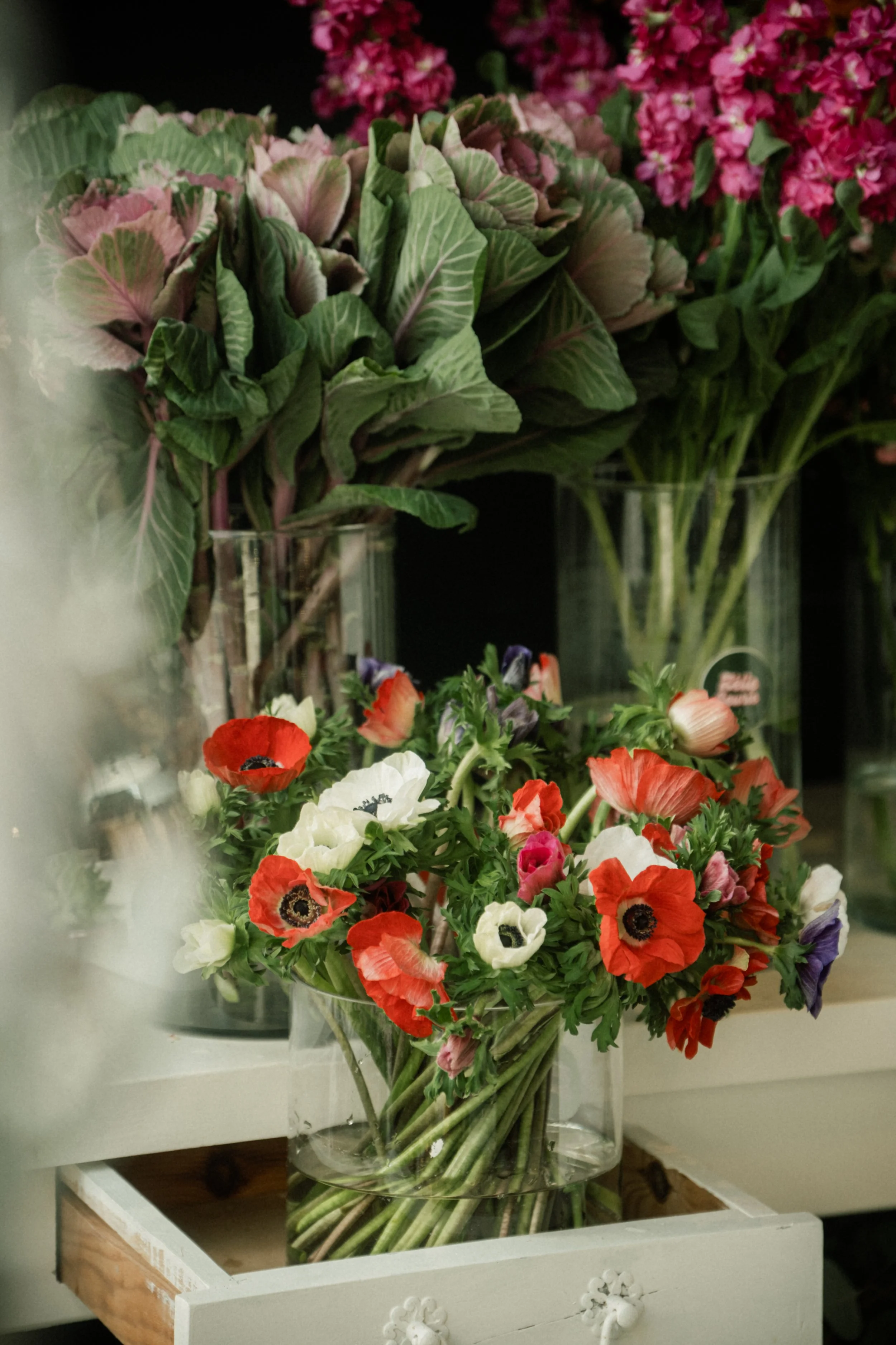 Bouquet de fleurs colorées comprenant des œillets dans un vase en verre sur une table dans une boutique de fleurs.