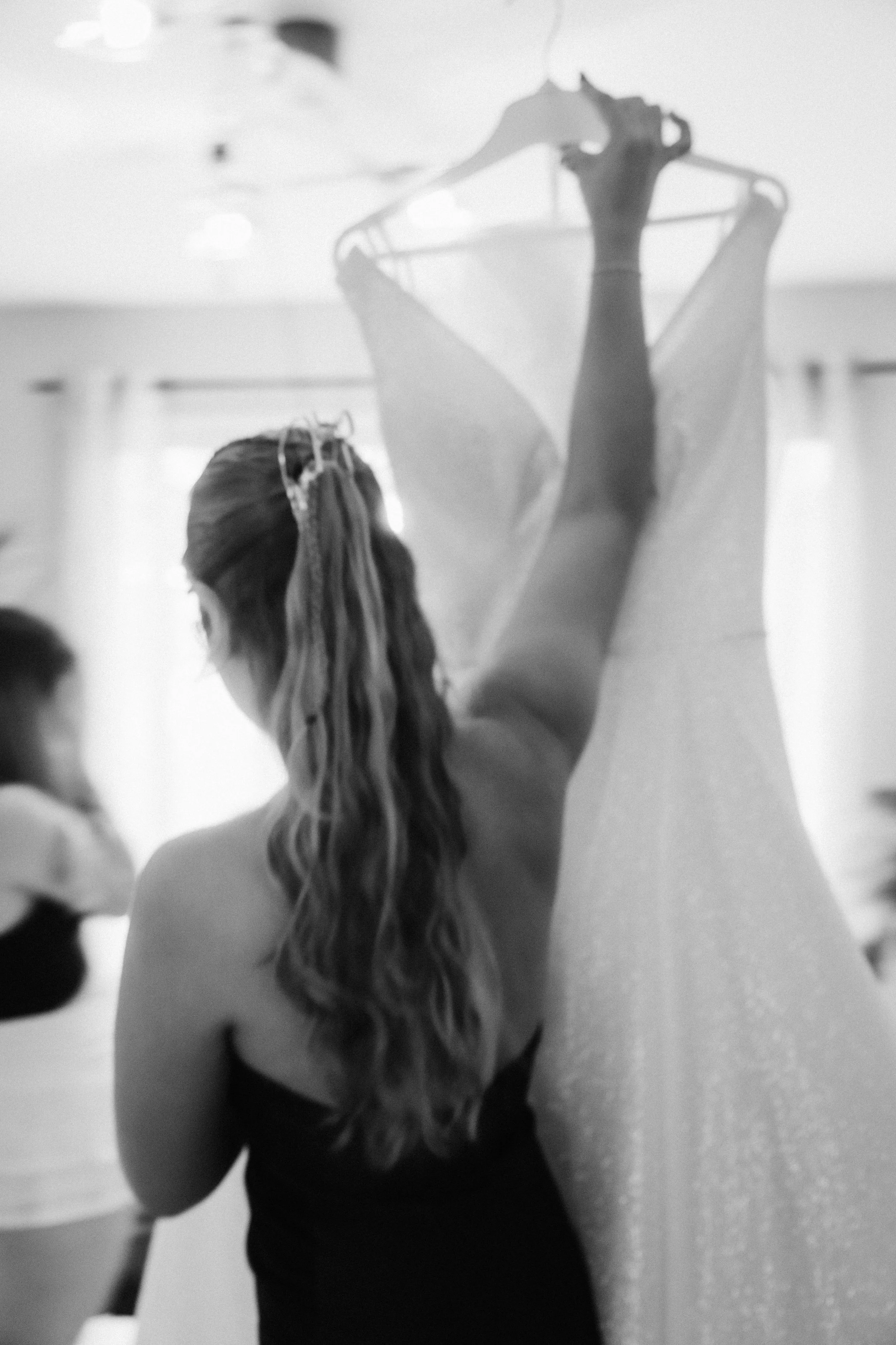 Une femme en train de faire de la danse ou du ballet, avec une robe longue scintillante, dans un espace intérieur.