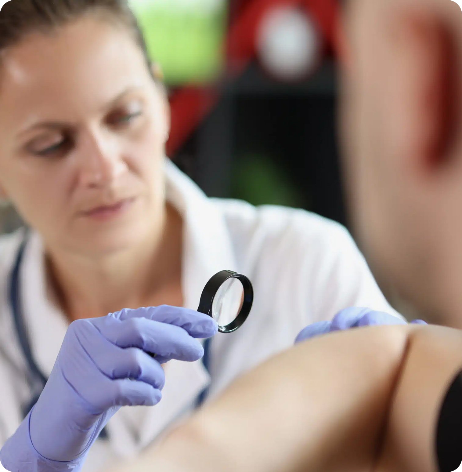 A healthcare professional examining a patient's skin with a magnifying glass.
