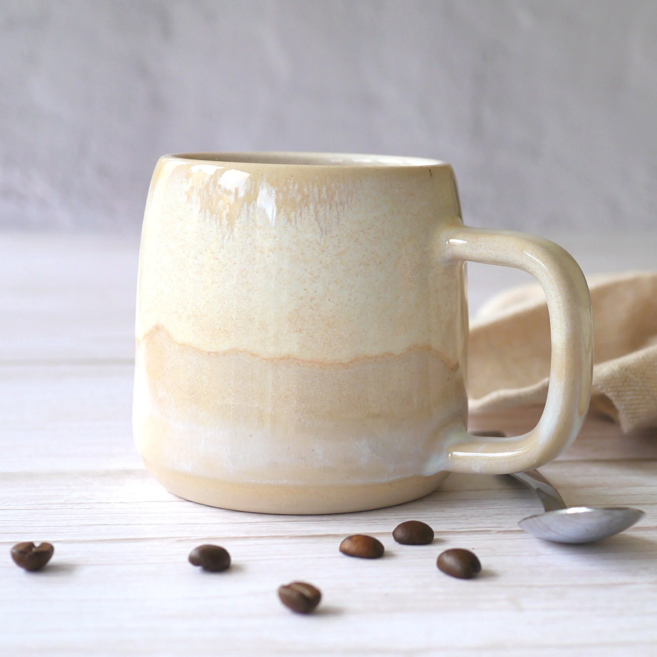 Hand-thrown ceramic mug. This mug features a beautiful blend of beige and white glazes, creating organic, flowing patterns that make every piece uniquely yours.