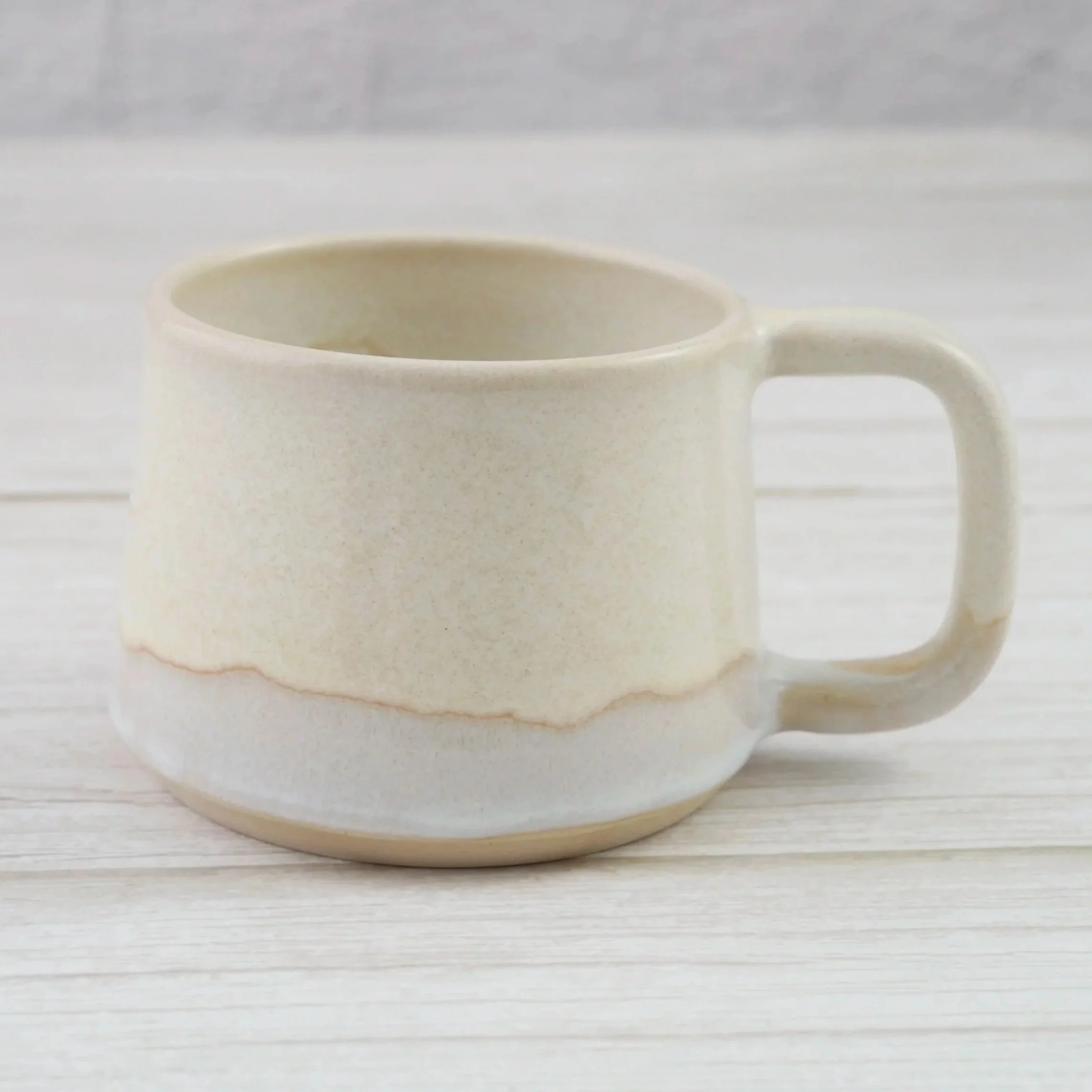 Hand-thrown stoneware mug. This mug features a beautiful blend of beige and white glazes, creating organic, flowing patterns that make every piece uniquely yours.