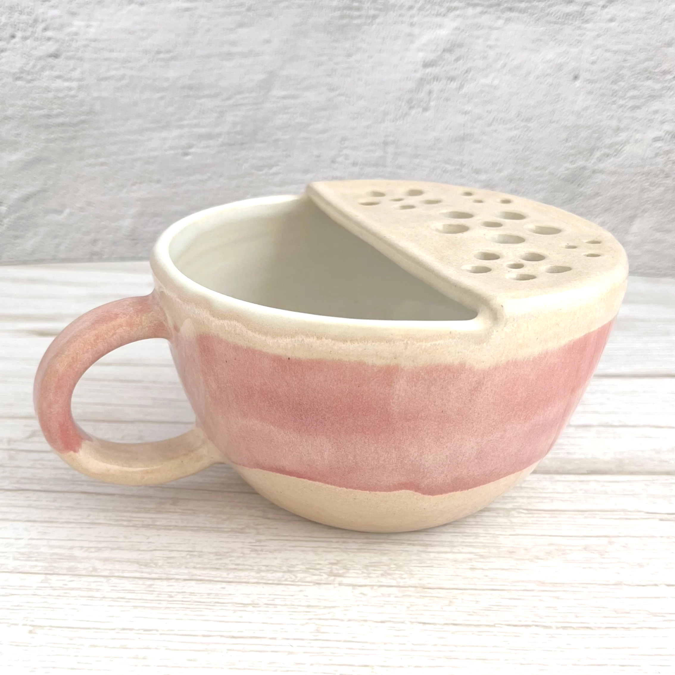 handmade stoneware berry bowl strainer with handle in a blush pink and cream glaze