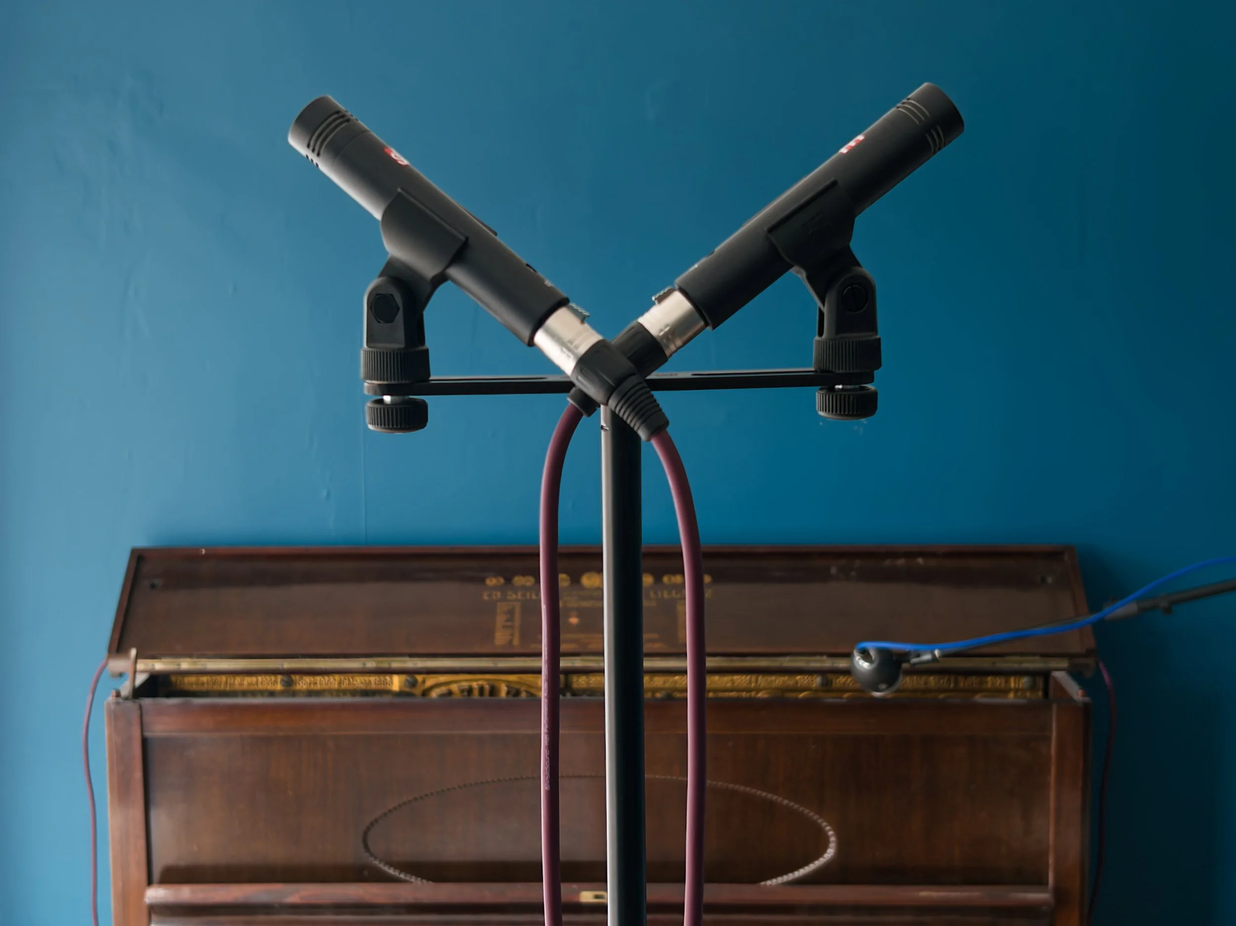 Pair of room microphones with piano in background.