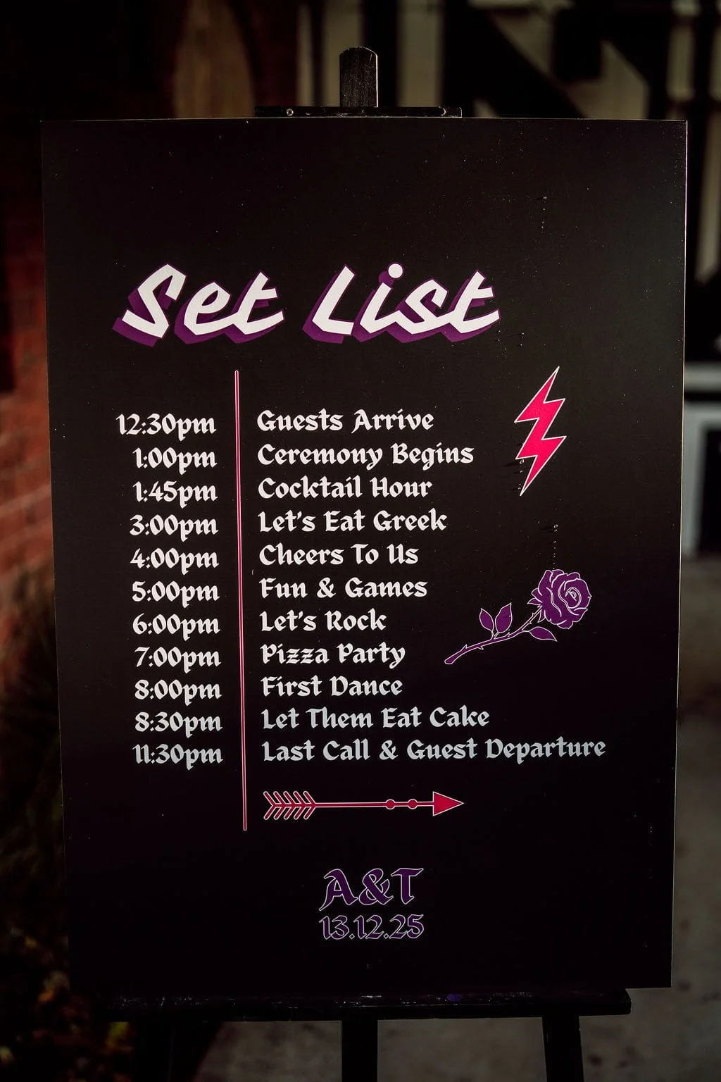 Event schedule board with text and graphics for a celebration, featuring a list of planned activities from 12:30 pm to 11:30 pm, including guest arrival, ceremony, cocktail hour, food, dancing, and departure, decorated with pink lightning bolt and pu