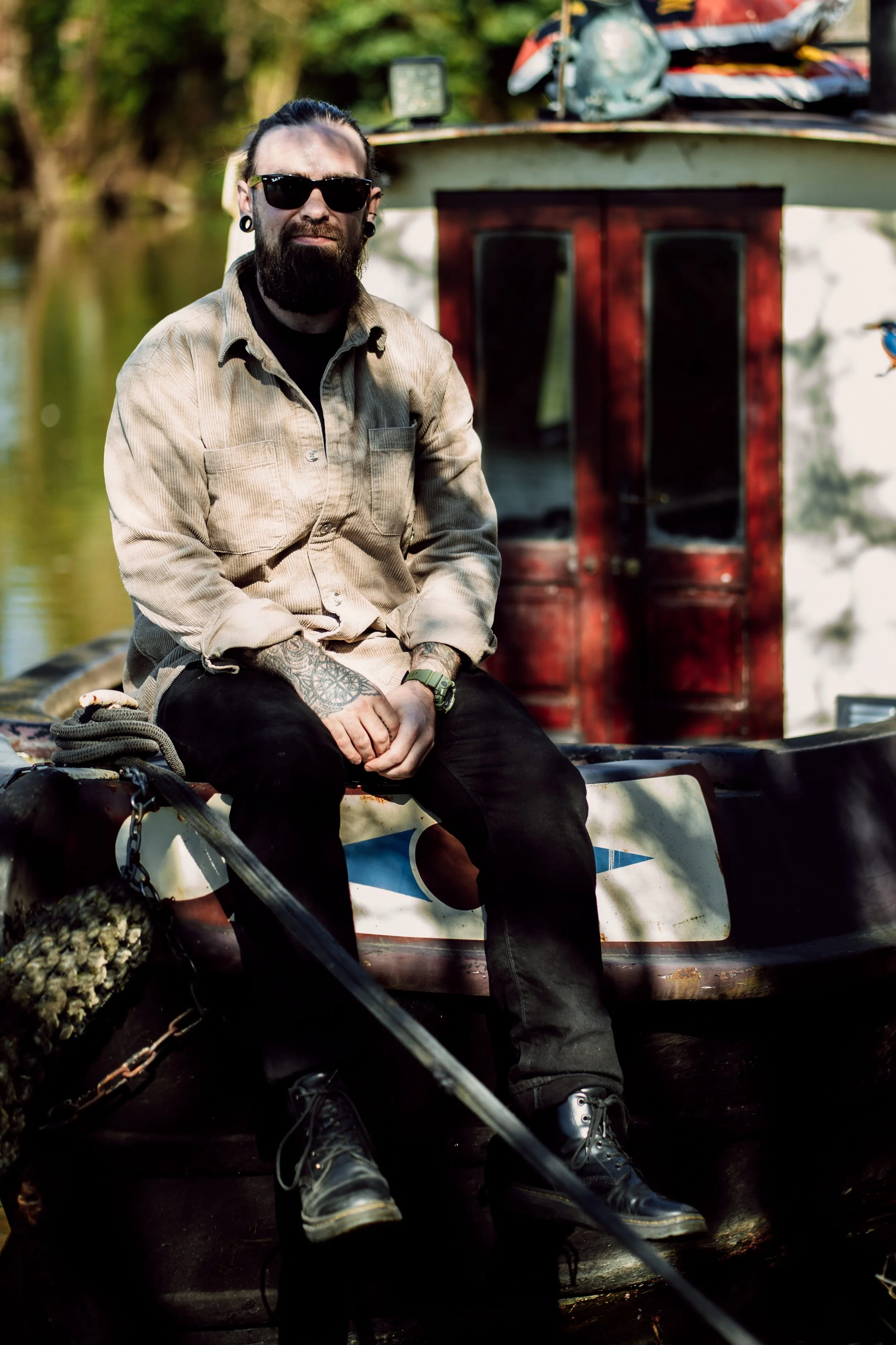 Alternative, gothic wedding photographer sat on the front of his narrow boat