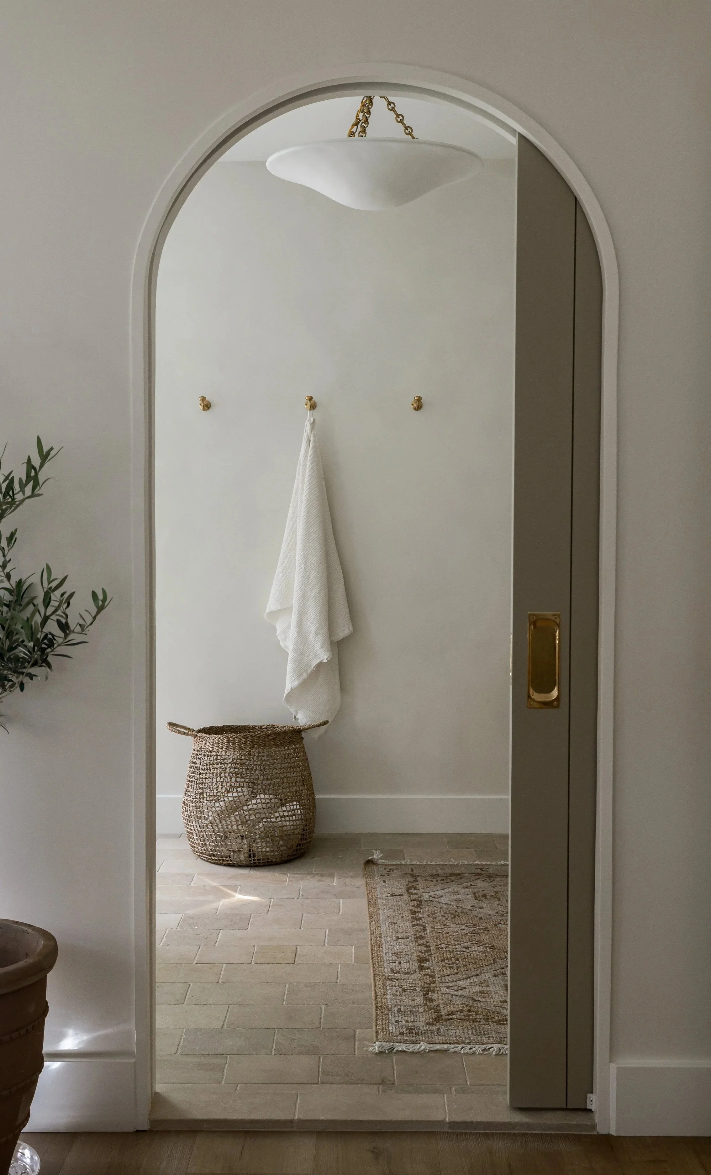 Softly curved door arch with warm neutral finishes and timeless architectural detailing designed by Stonecoast Interiors in Annapolis, Maryland.