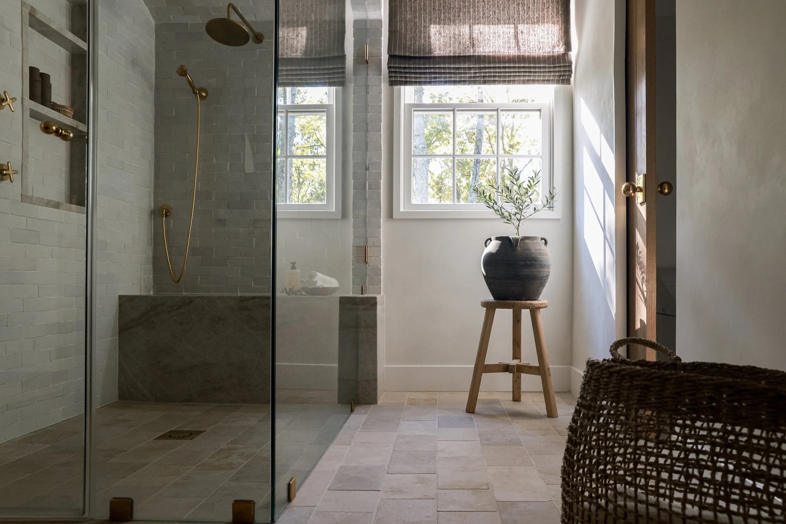Organic stone shower design with natural tile, soft neutral tones, and spa-like finishes by Stonecoast Interiors, a full-service interior design studio in Annapolis, Anne Arundel County Maryland.