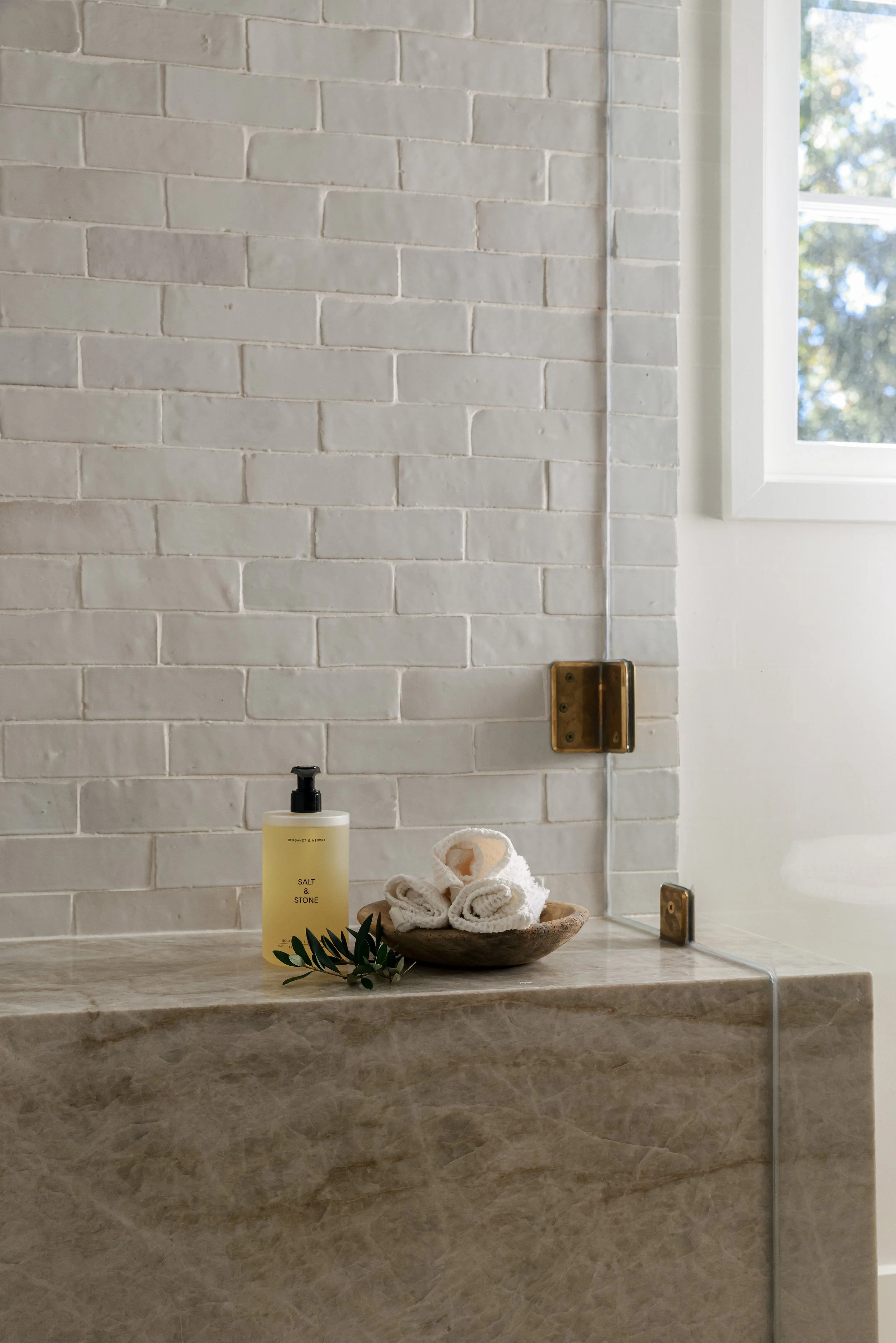 Custom bathroom shower with layered neutrals, natural materials, and refined detailing designed by Stonecoast Interiors in Annapolis, Maryland.