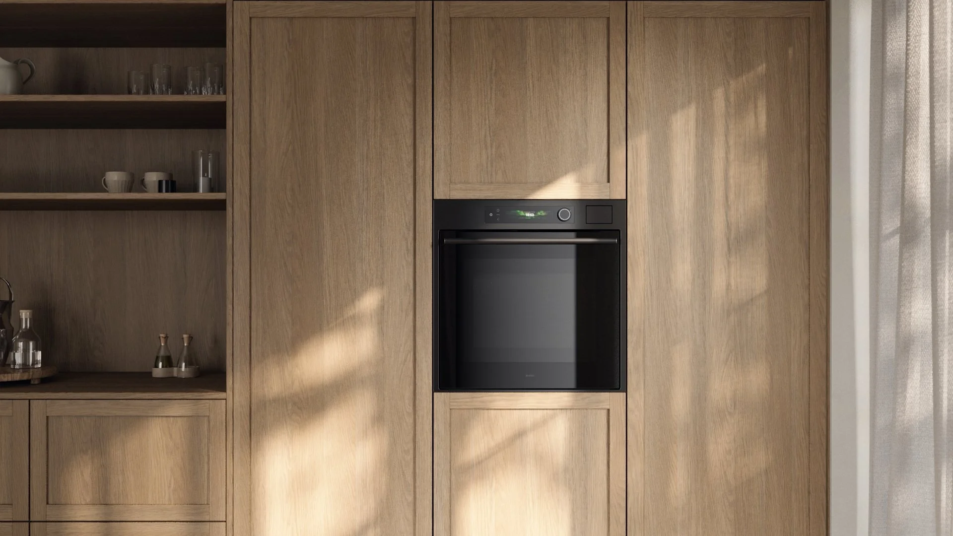 Built-in black oven set in a wooden kitchen cabinet with shelves and glassware on the left, and a partially visible curtain on the right.