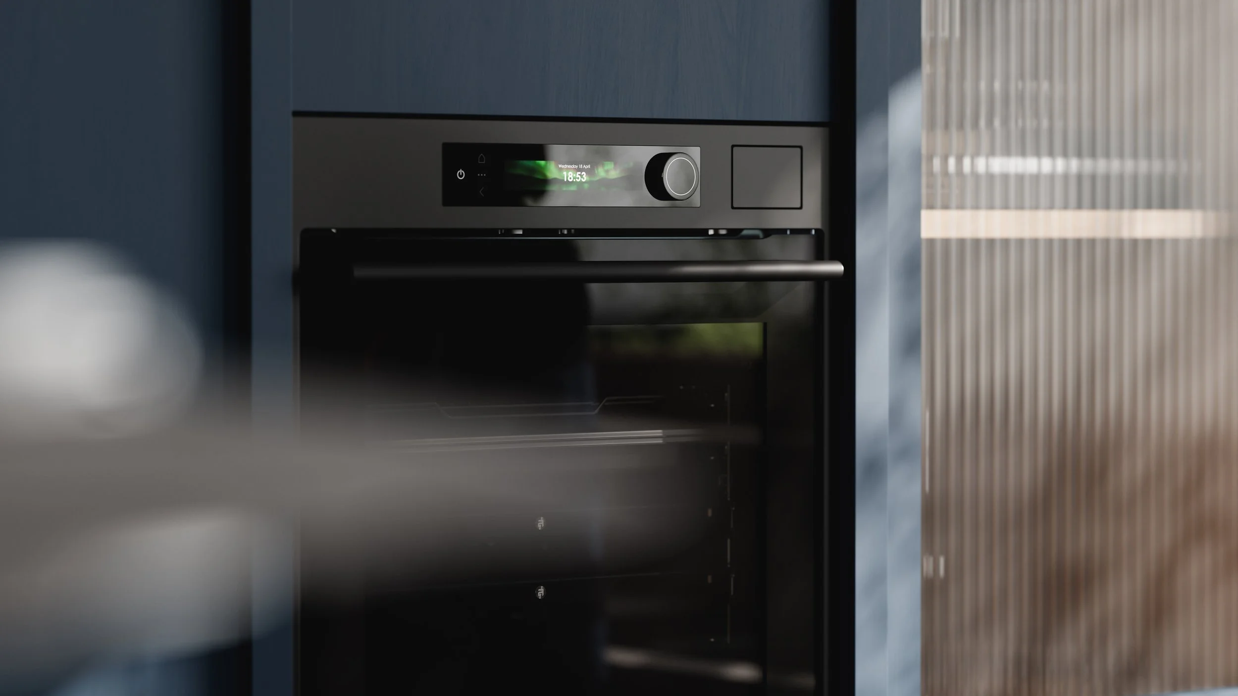 Close-up of a modern built-in oven with digital display and knob, set into a kitchen cabinet.