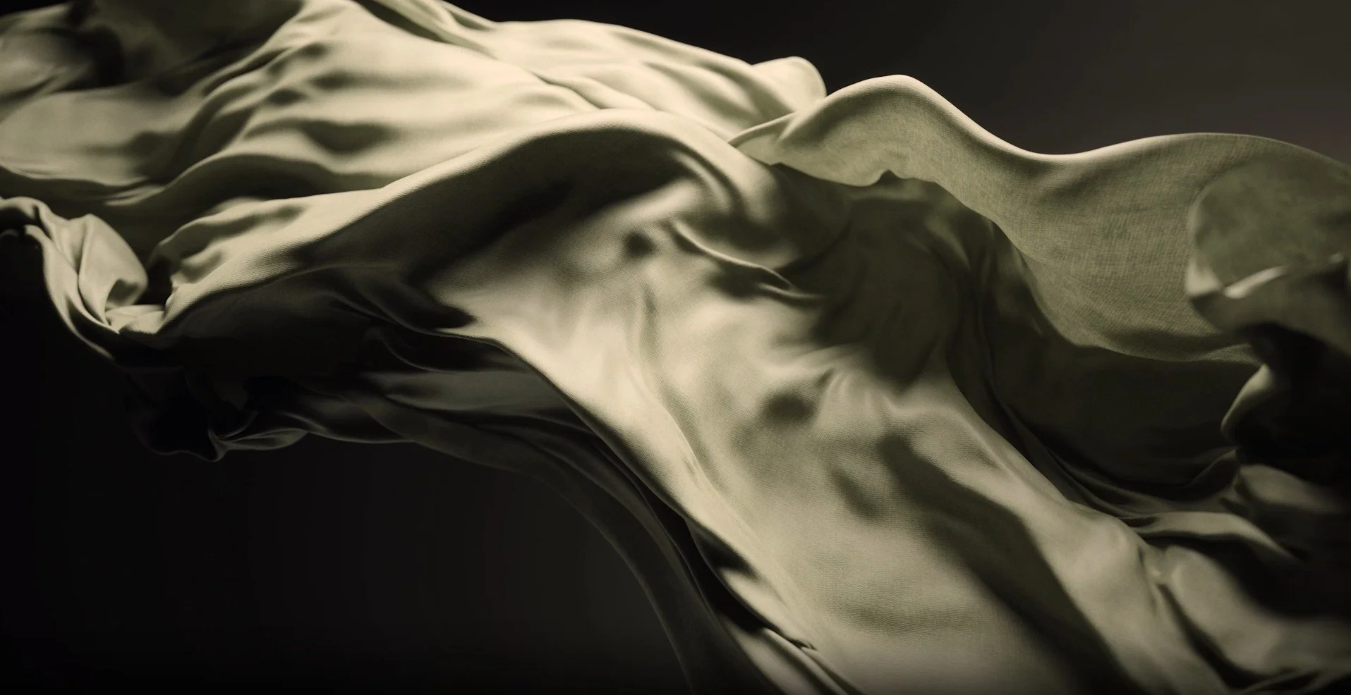 Close-up of a draped, crumpled fabric in a dark setting with shadows.