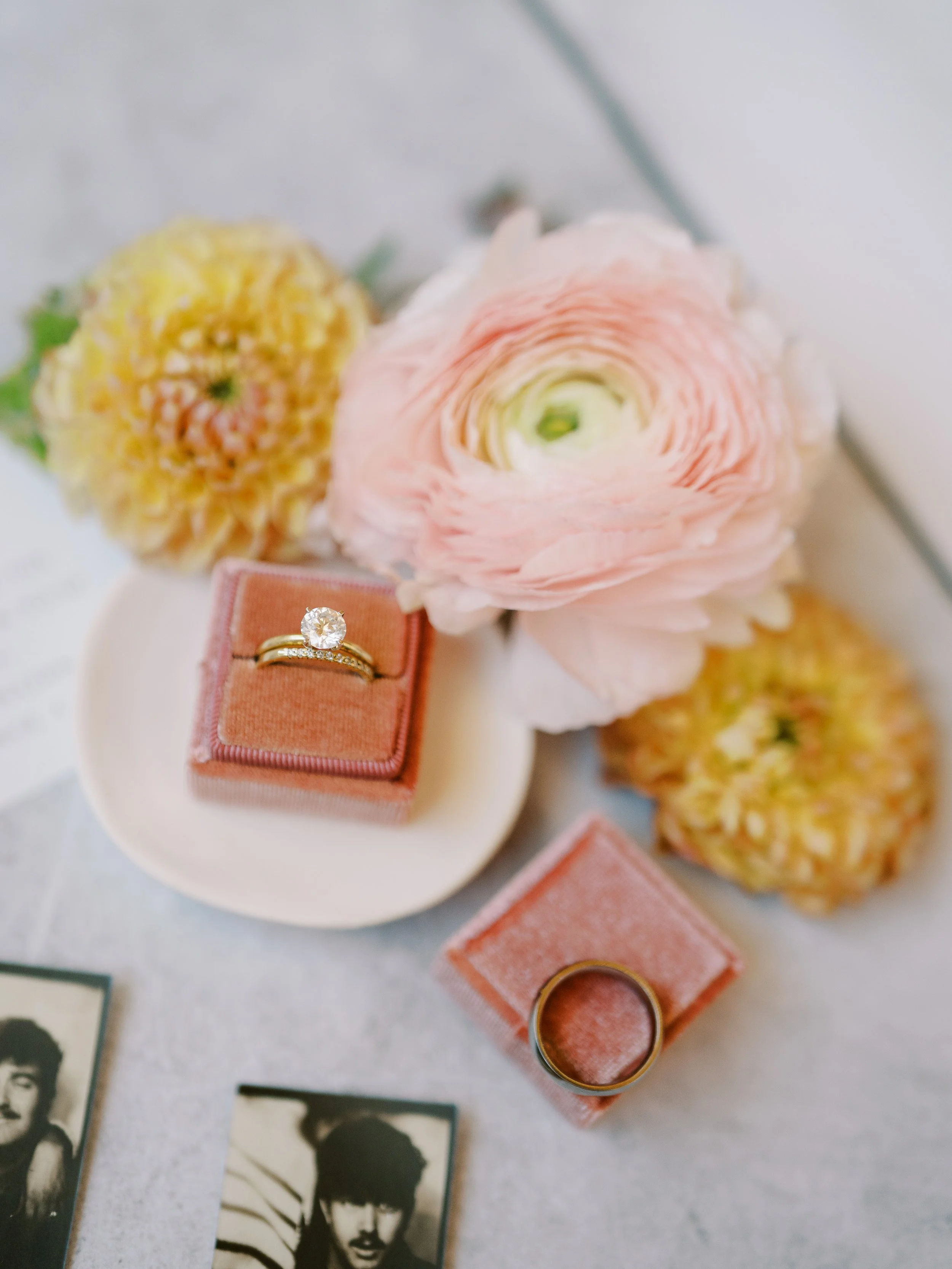 Wedding rings in velvet boxes surrounded by flowers