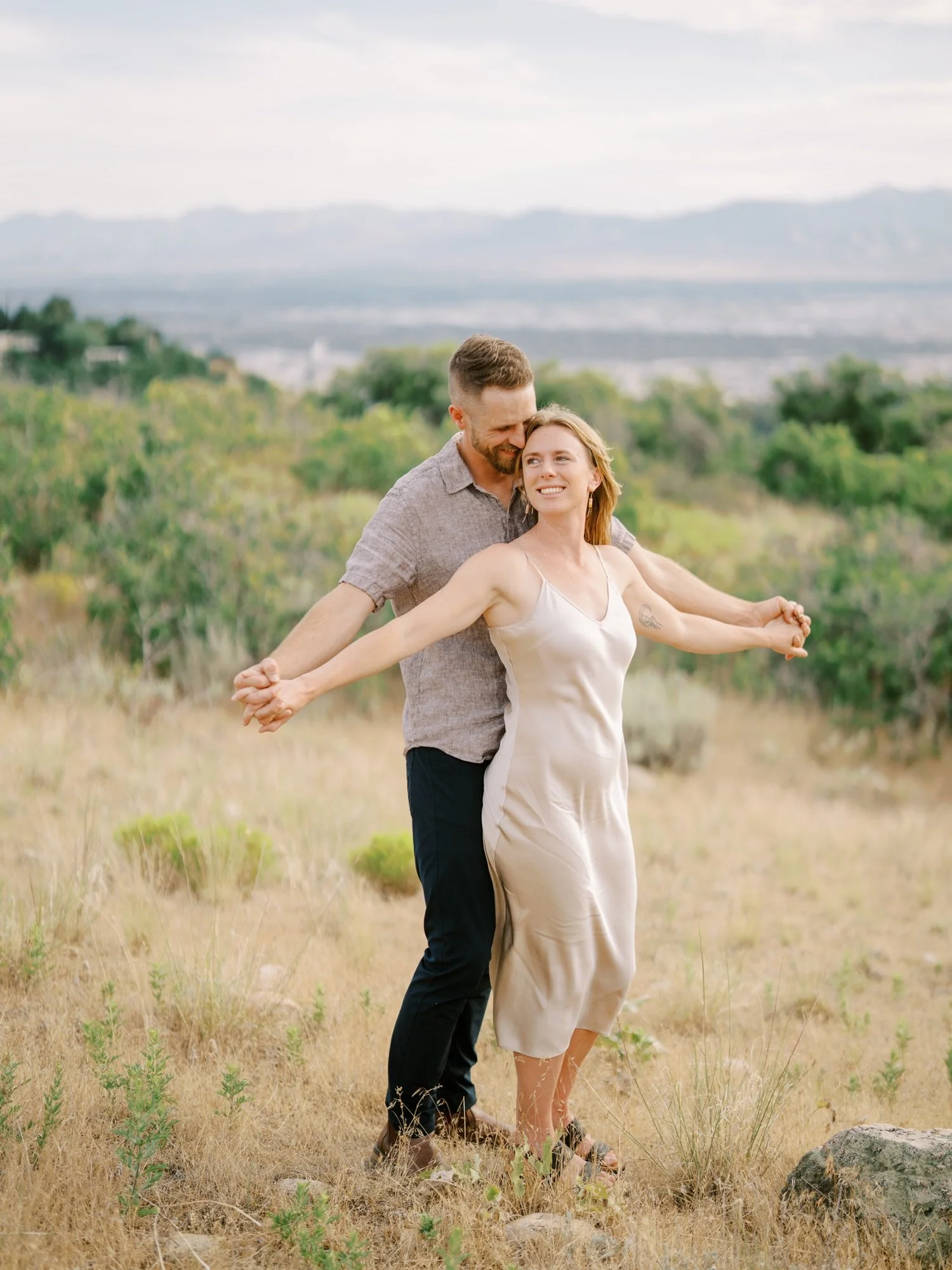 Couple laughing and moving together through golden grass