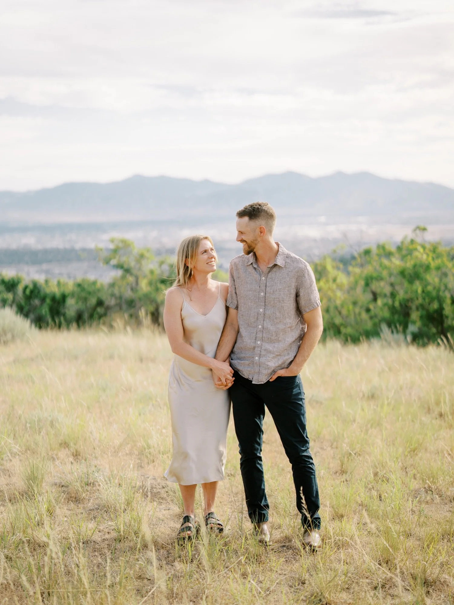 Couple looking at each other in a meadow with mountain views