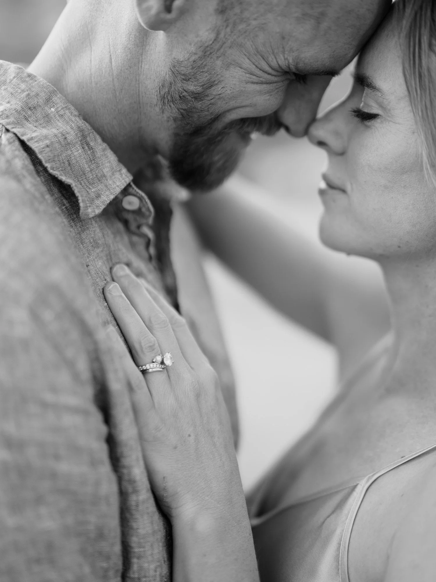 Black-and-white close-up of a couple touching foreheads