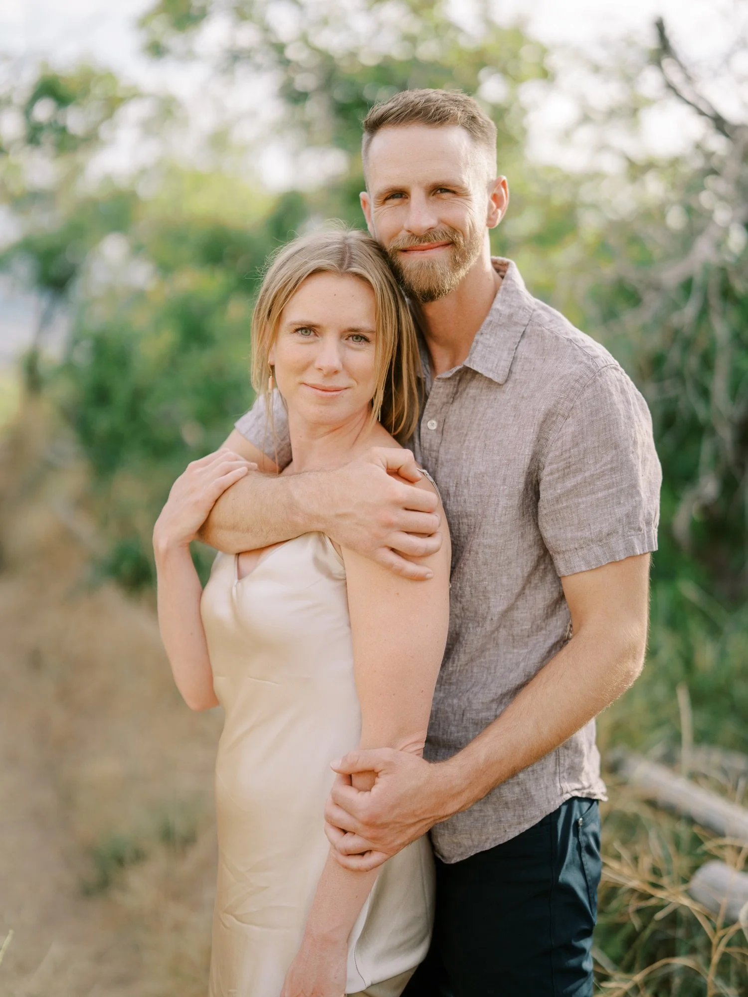 Engaged couple smiling together in soft outdoor light