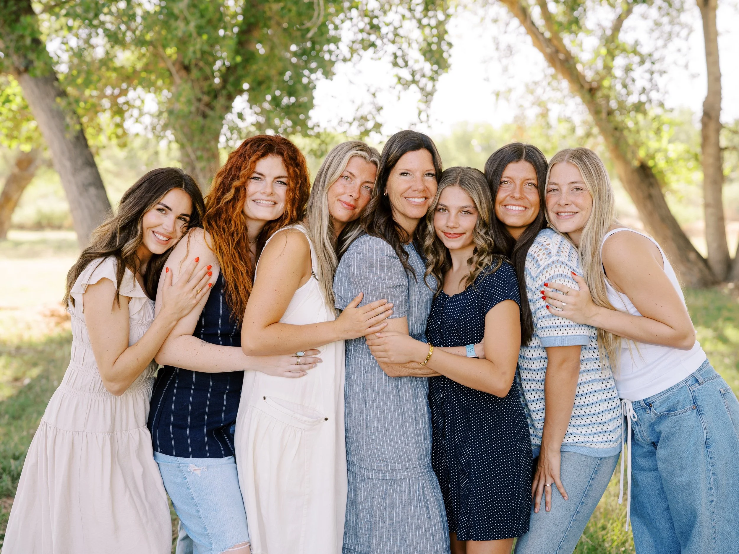 Seven women standing close together and smiling.