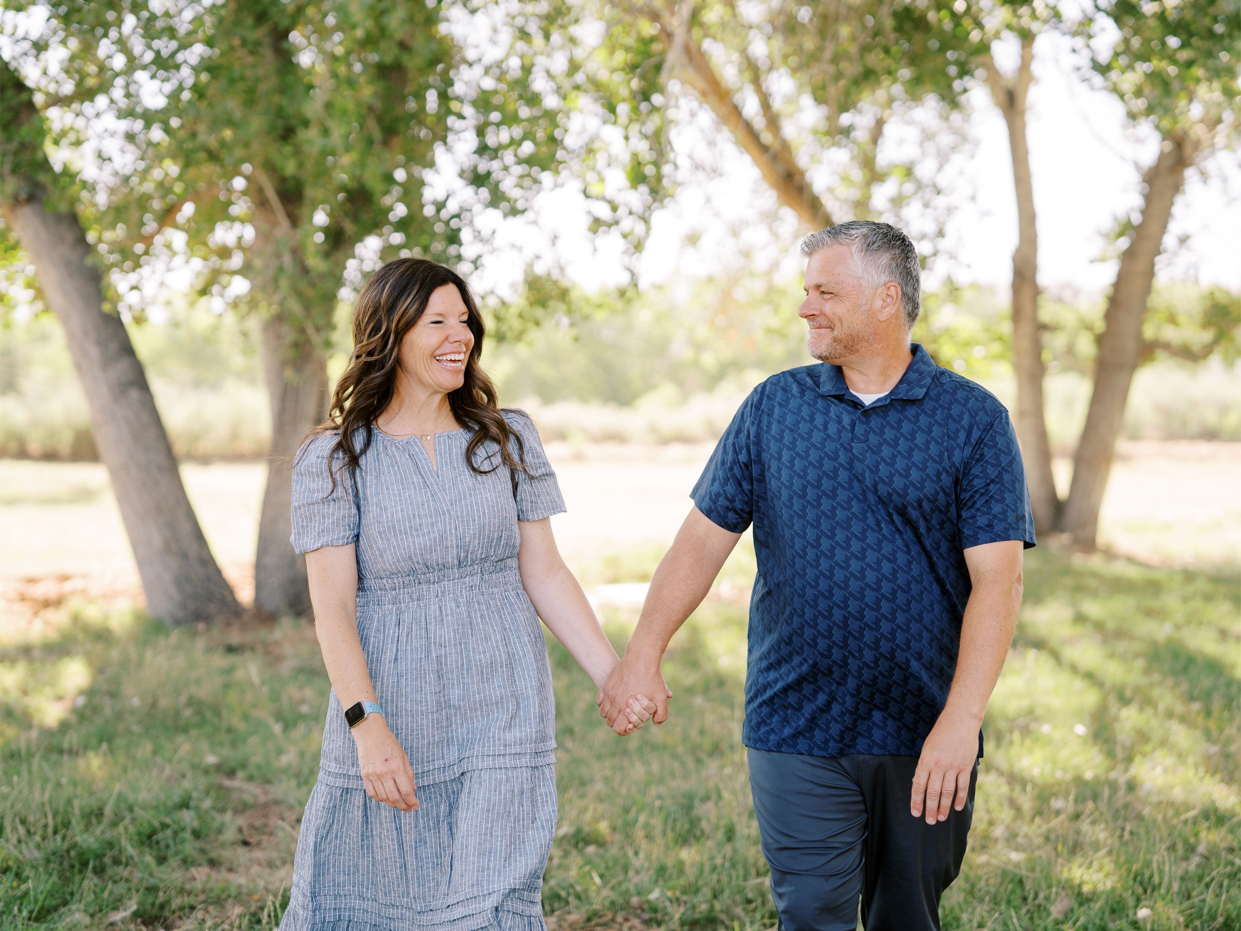 A couple holding hands and smiling at one another.