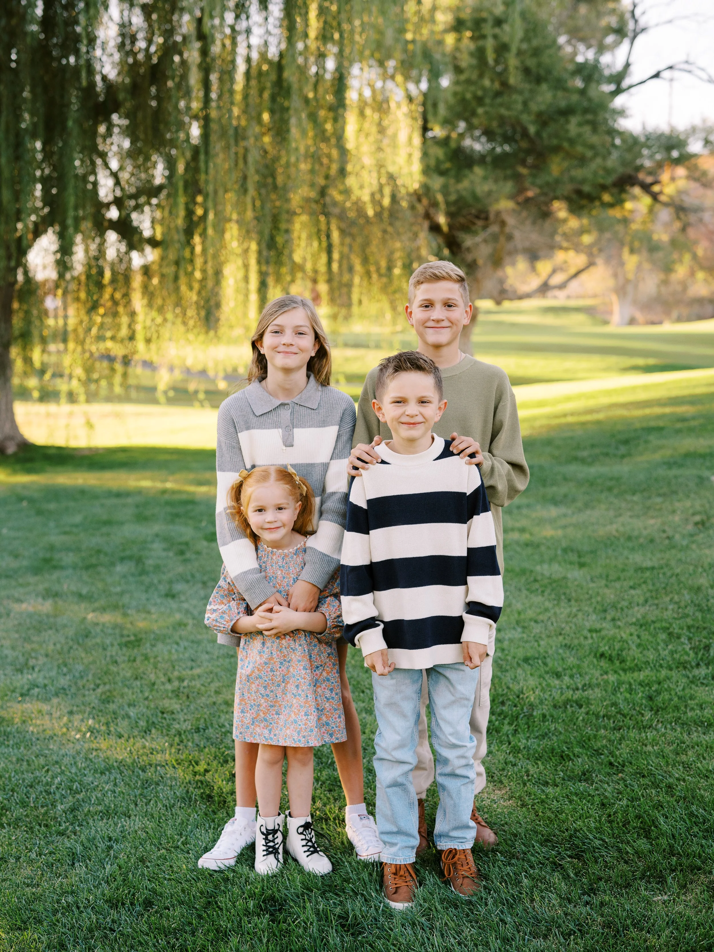 Four children smiling together during their family mini session
