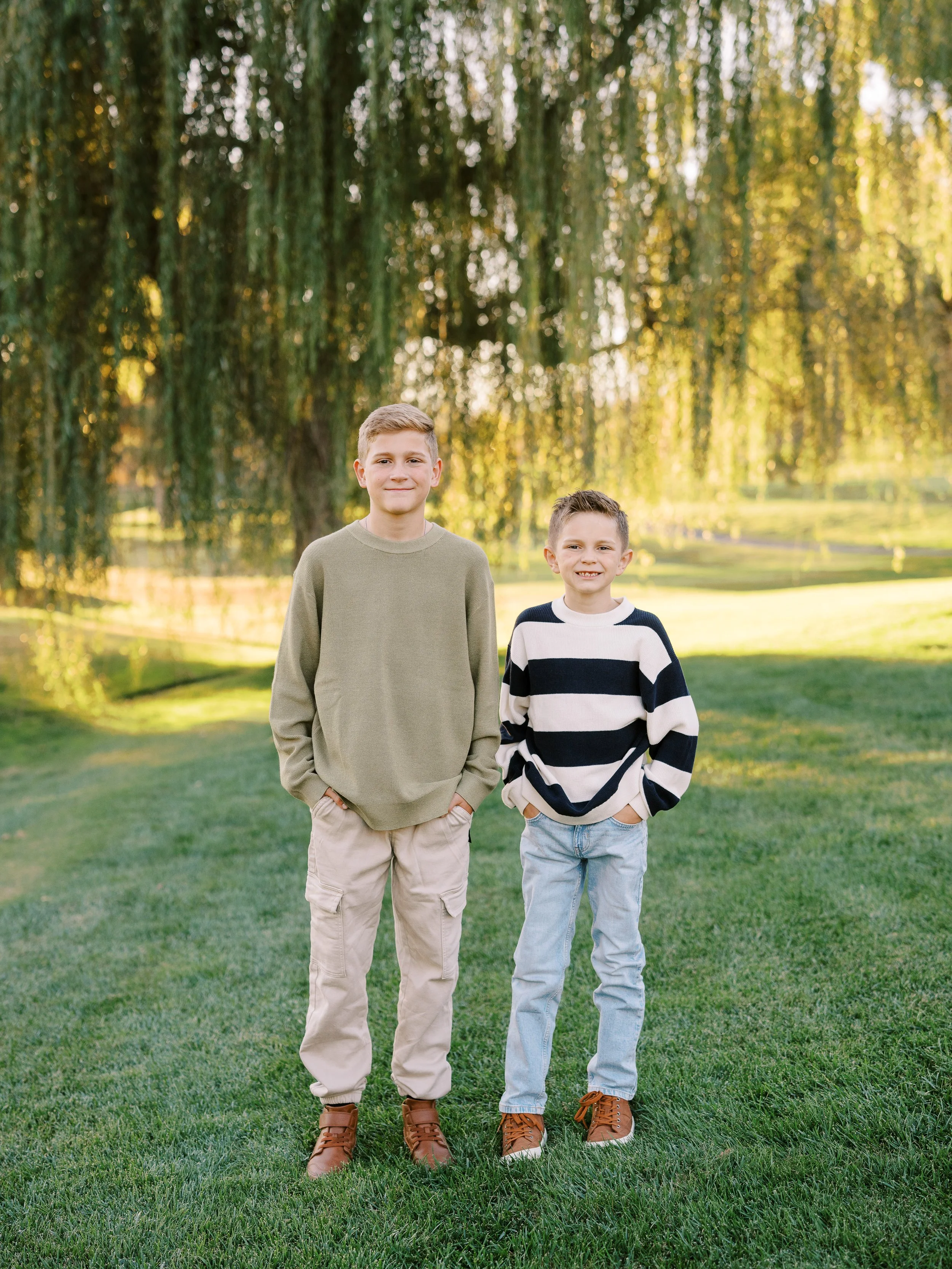 Two brothers standing side by side on the lawn