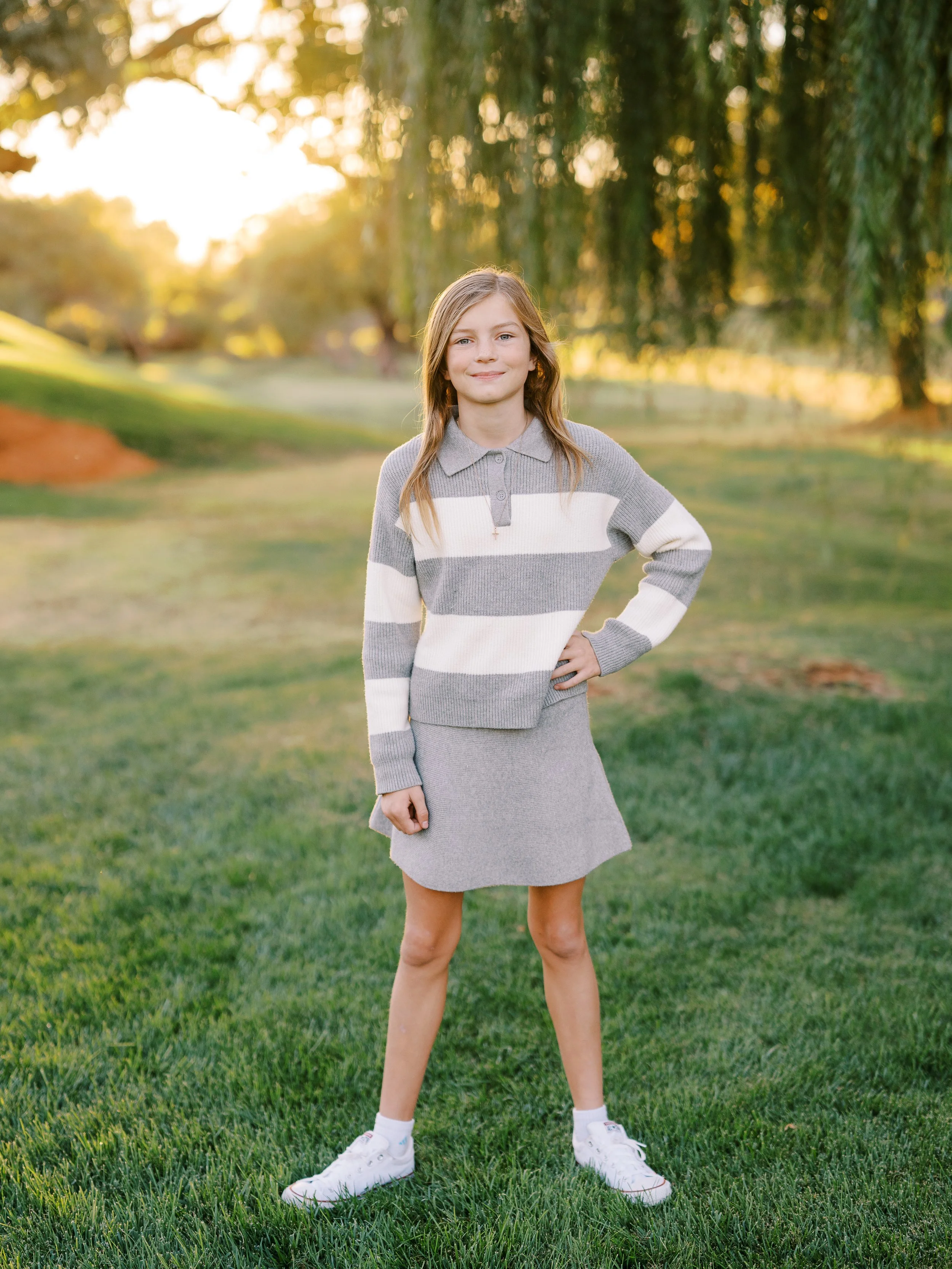 Girl in a gray striped dress posing with one hand on her hip