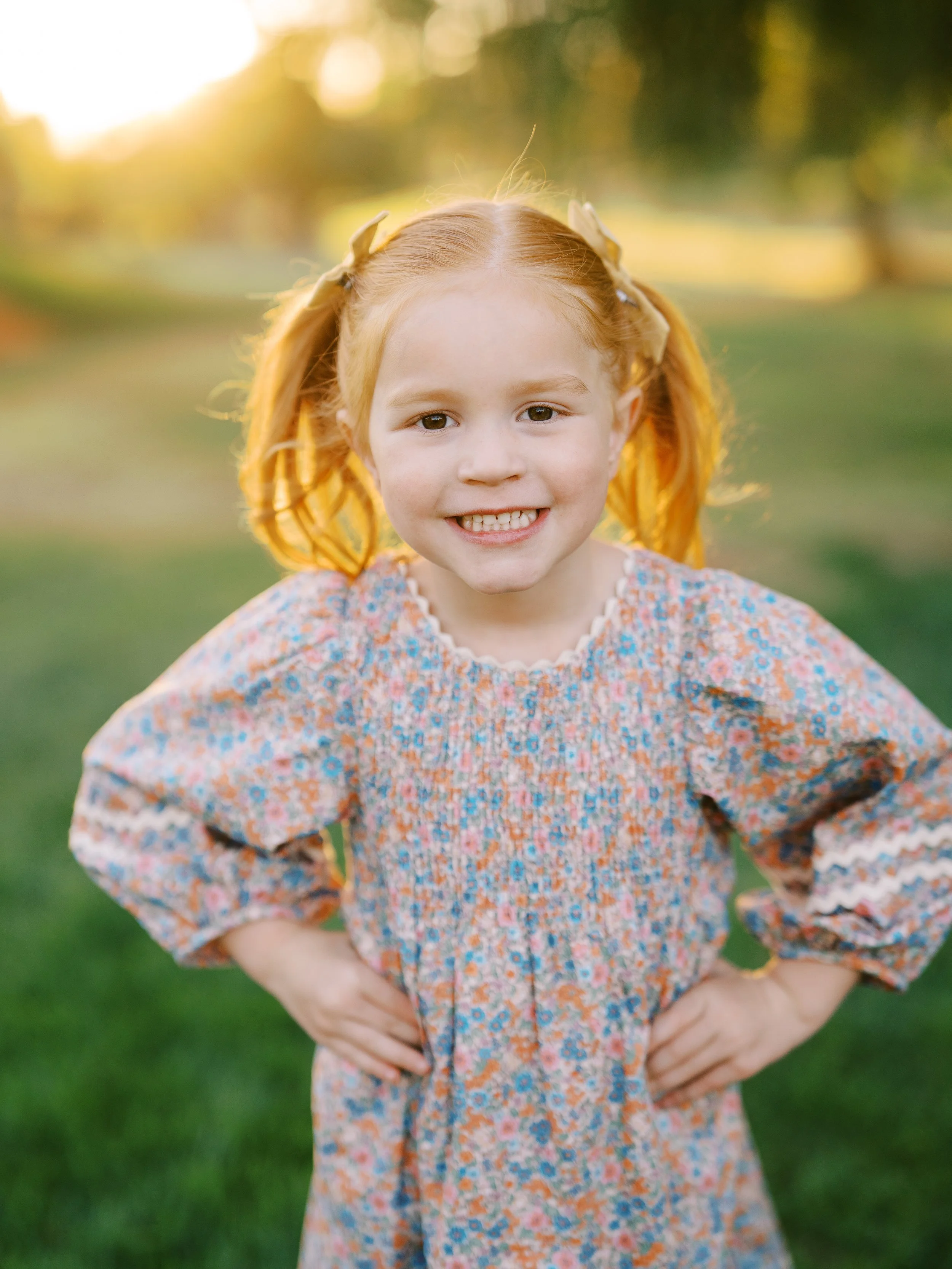 Smiling young girl with red pigtails and a floral dress