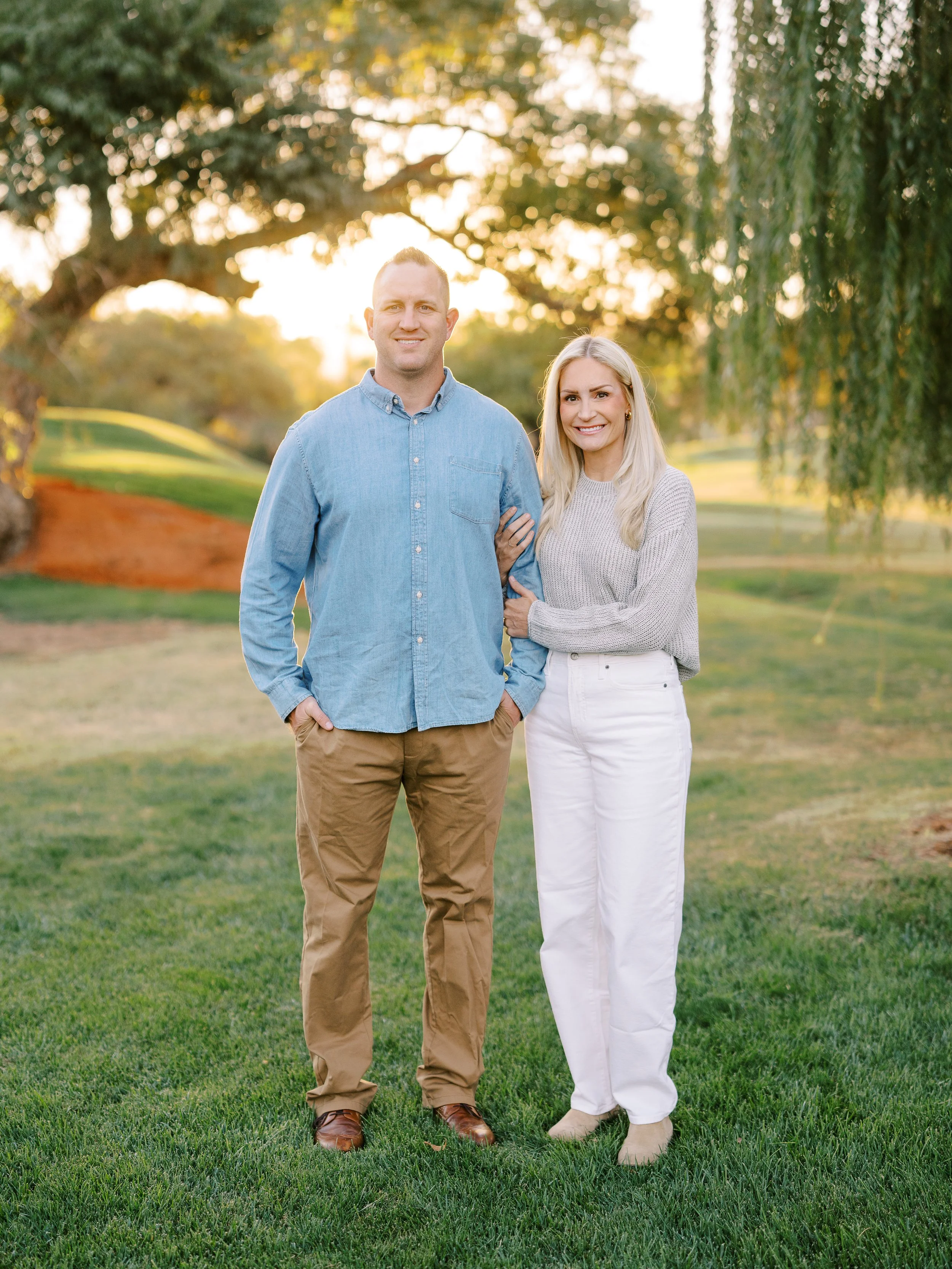 Parents standing side by side on the grass at Red Hills Golf Course