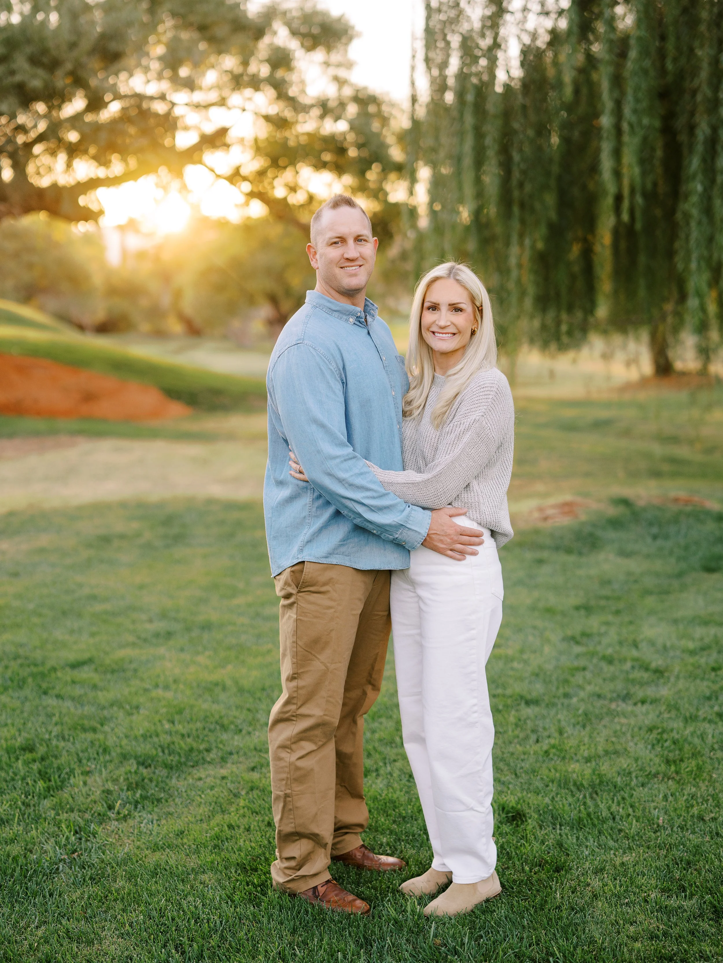 Couple embracing beneath the trees during their family session