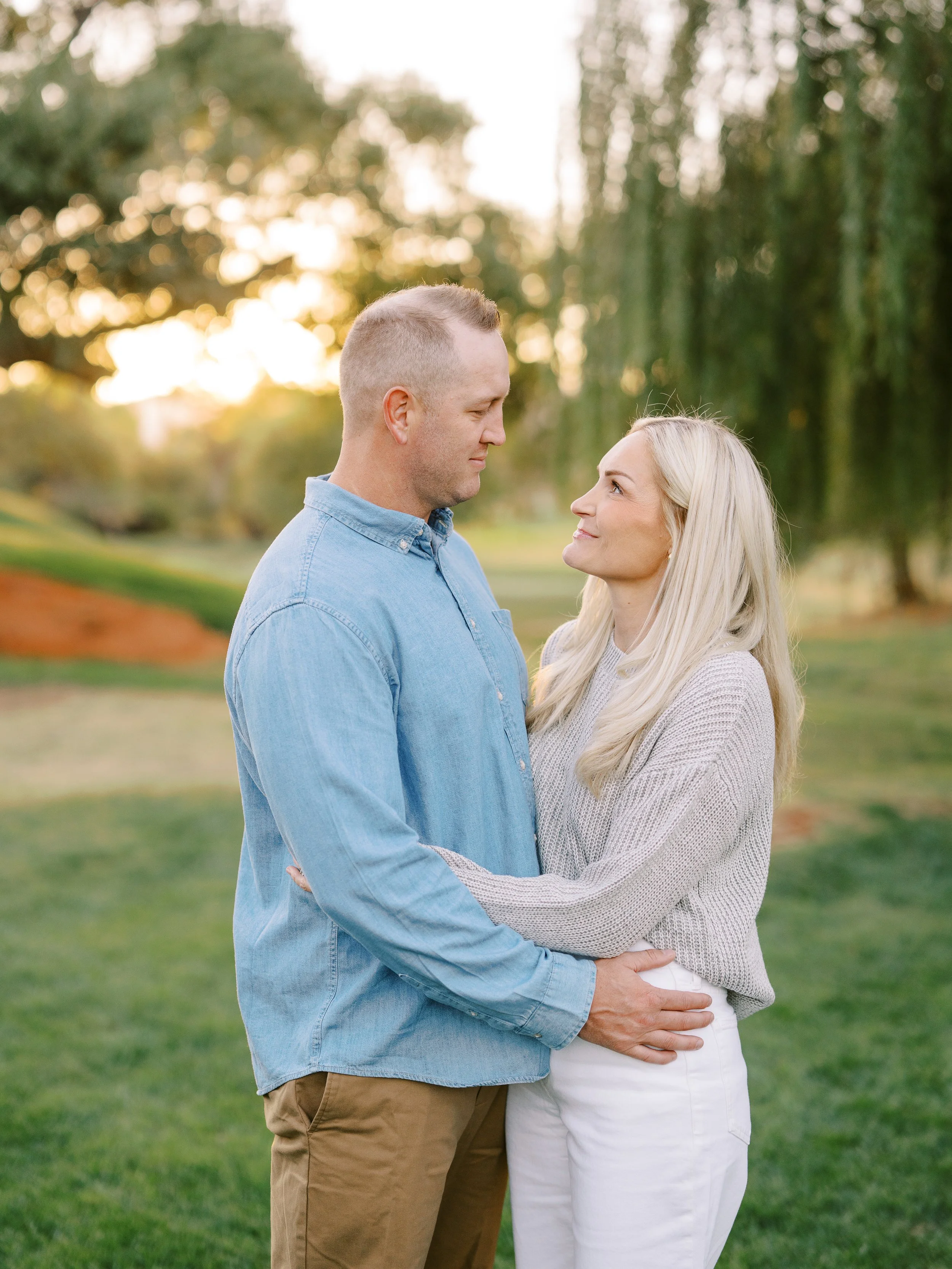 Couple facing one another and holding each other at the waist
